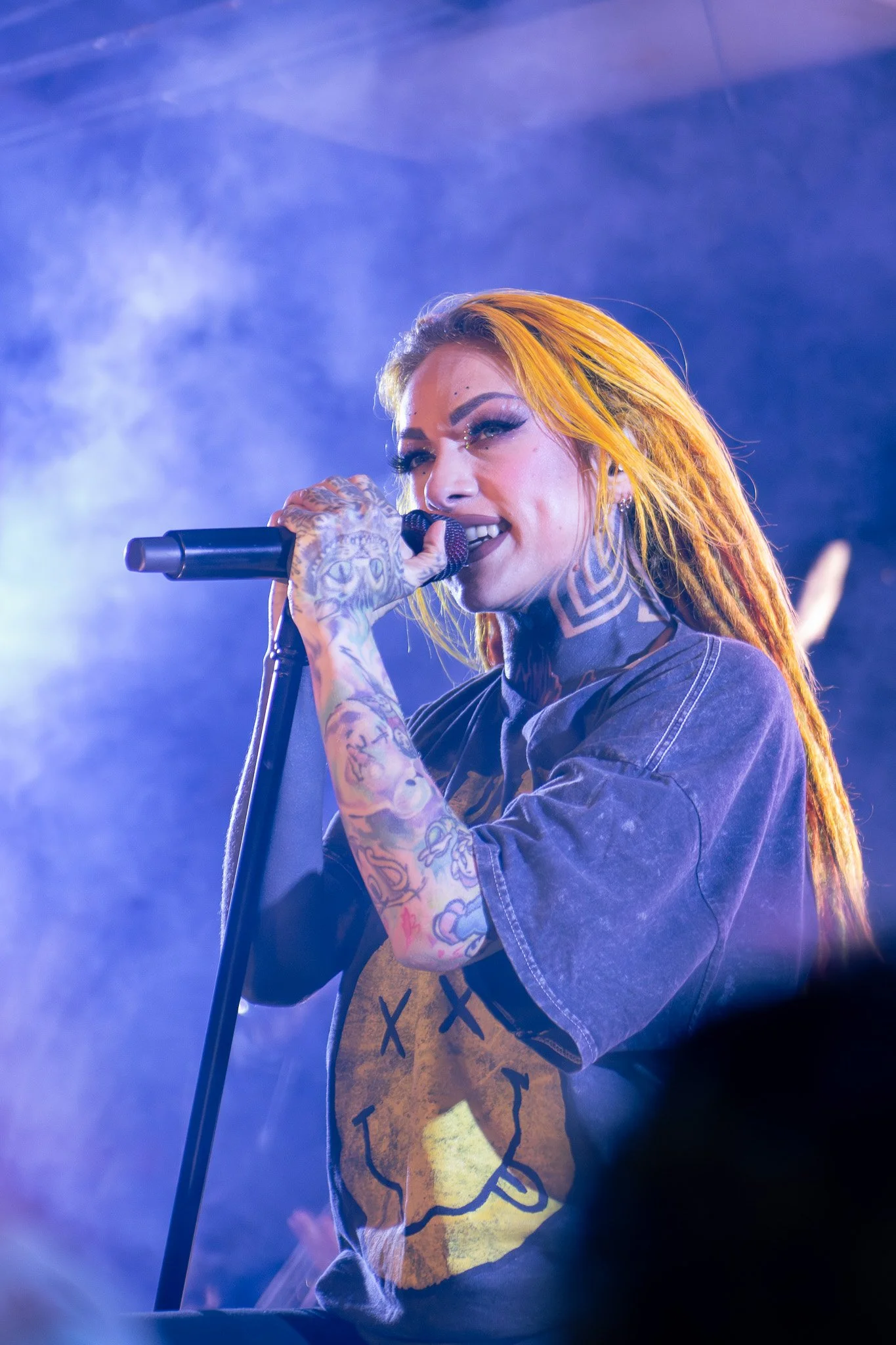 a woman smiling on a stage with a microphone