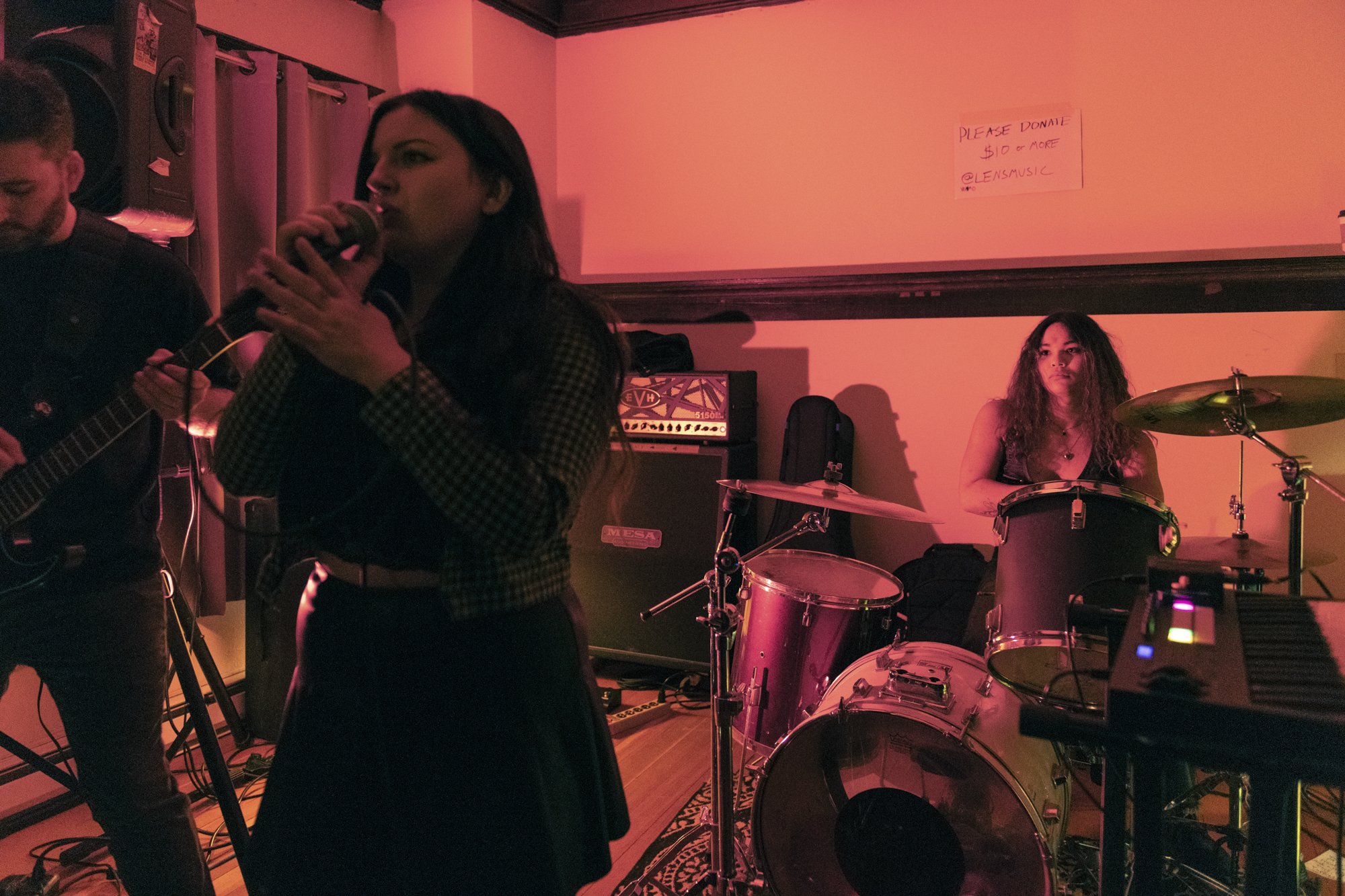 a live concert photograph of the lead singer and drummer performing a live show