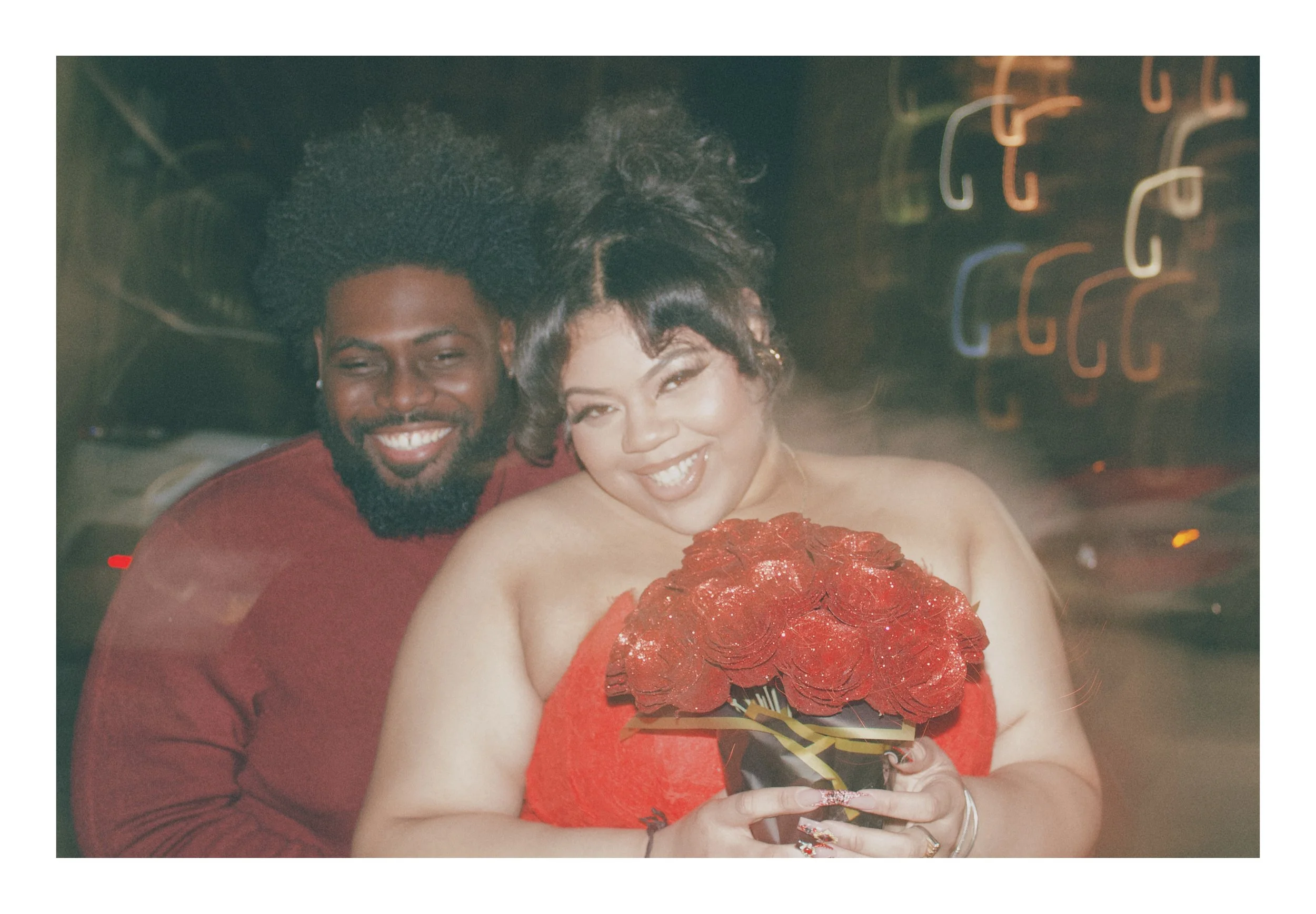 Joyful couple smiling together while holding a bouquet of red roses for a New England lifestyle photography session in Farmington.