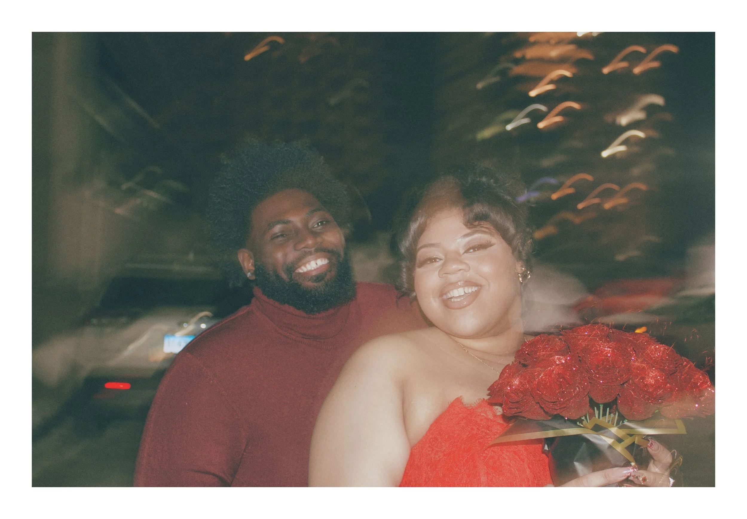 Happy couple posing together outdoors at night with a red rose bouquet for a timeless family photo milestone in Greater CT.
