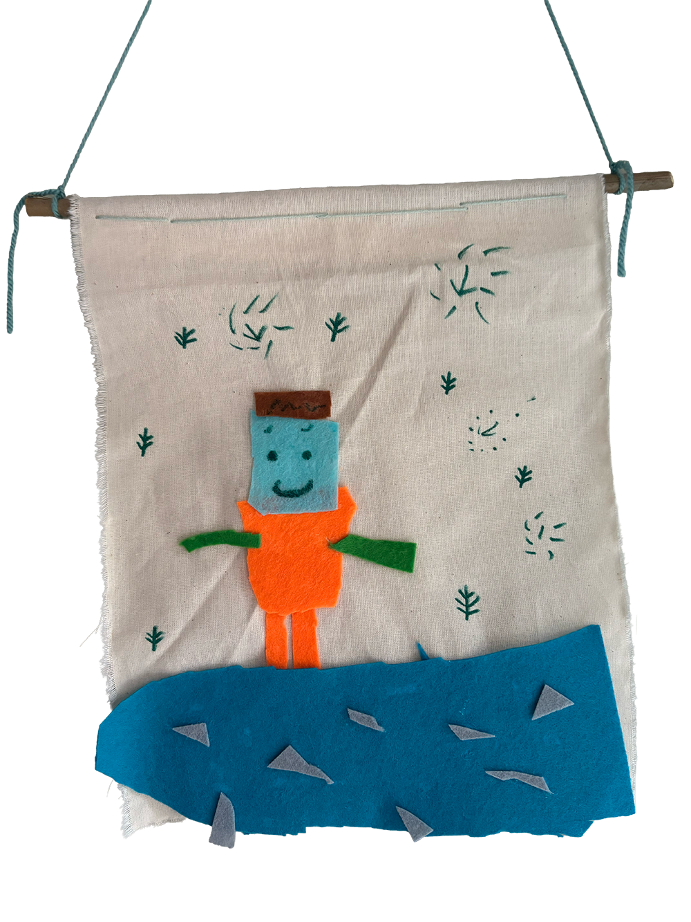 Felt wall hanging depicting a character with a blue face, brown hair, orange shirt, green arms, and orange legs, standing on a blue iceberg with ice chunks, surrounded by green scribbles representing fireworks or sparks.