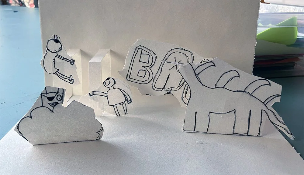 Paper cutout scene with doodles of children, a cloud with a face, a dinosaur.