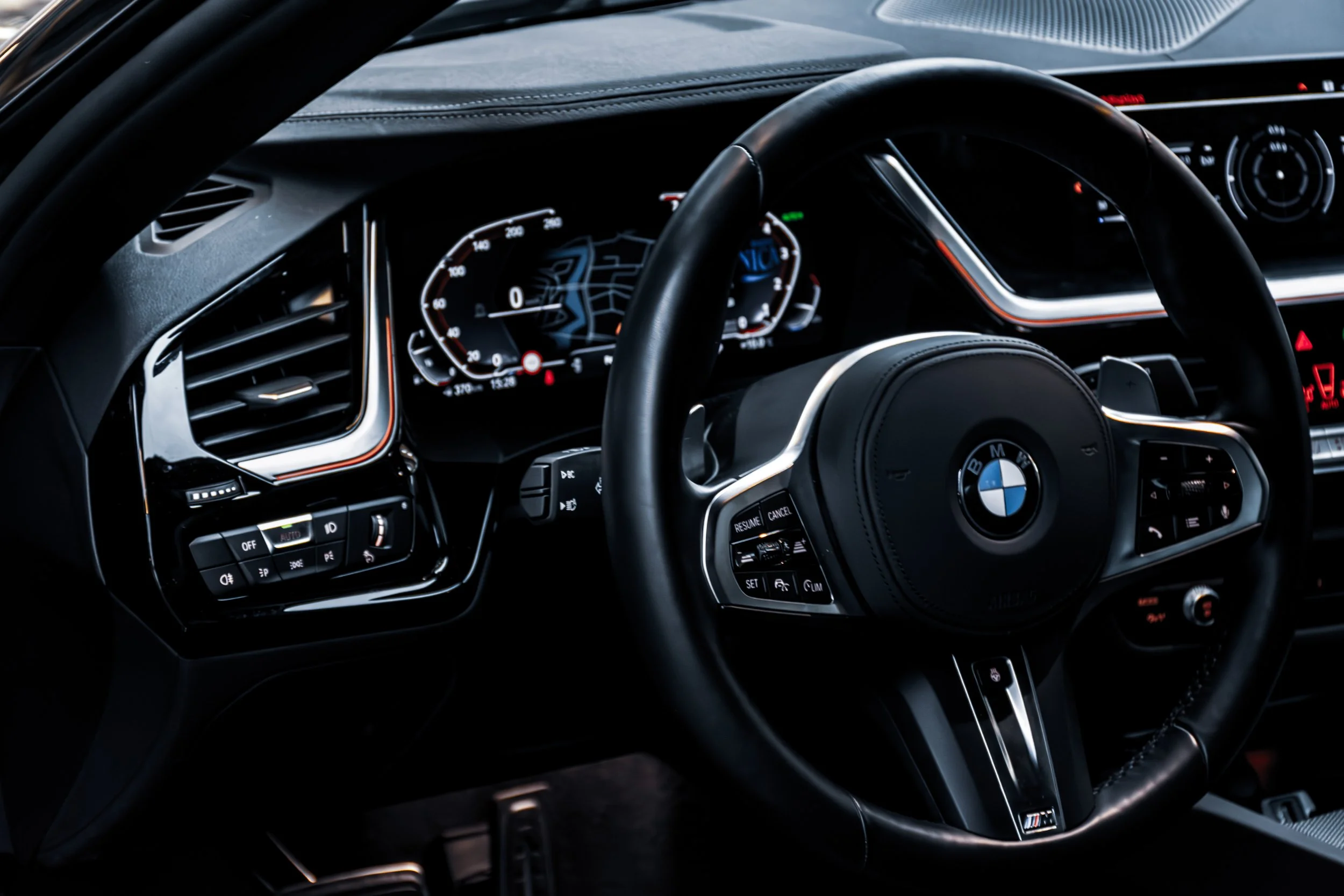 Interieur van een BMW auto, met een digitaal dashboard en een multifunctioneel stuurwiel.