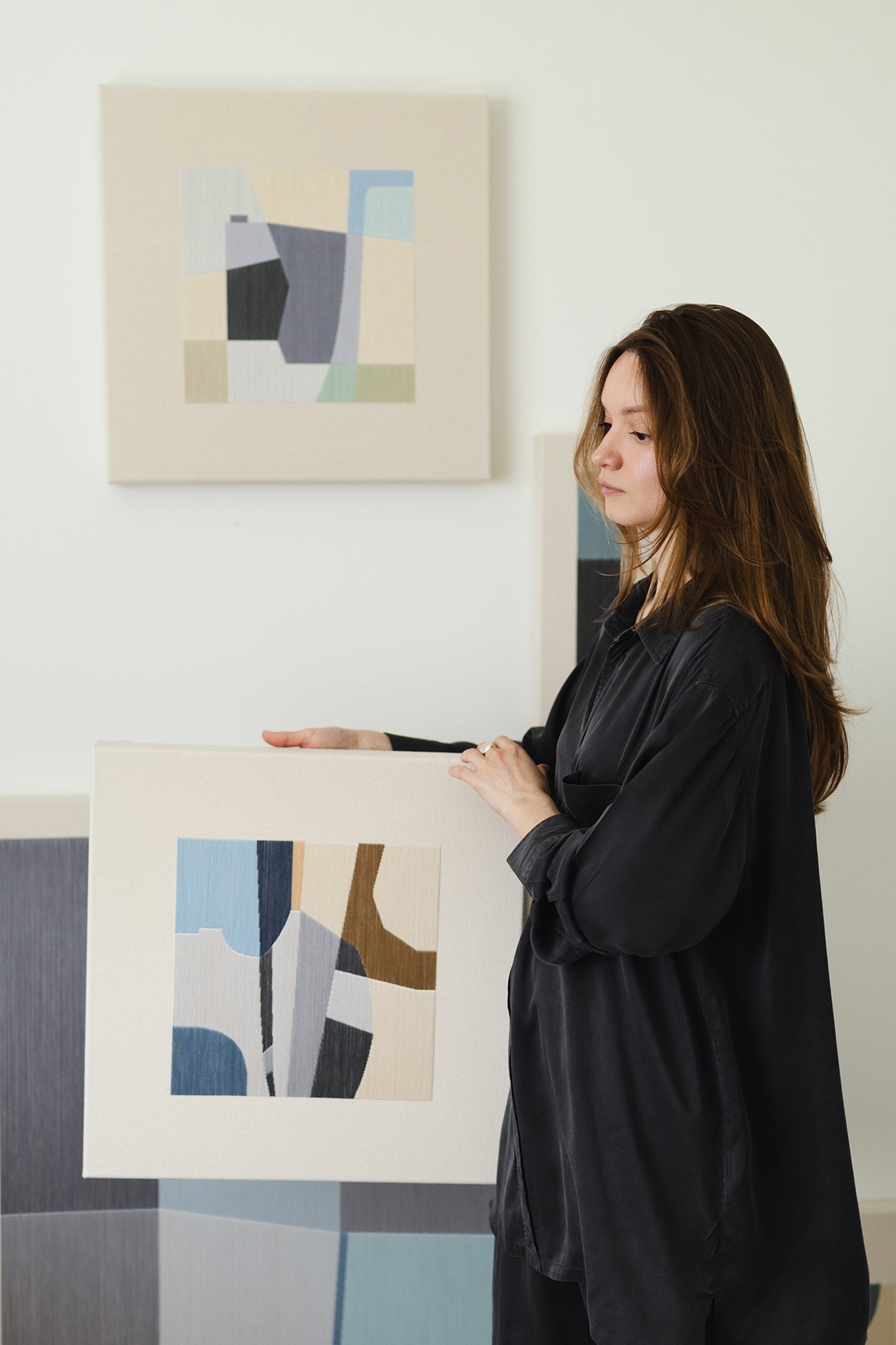 Kateryna Сhernetska in studio holding contemporary geometric textile and thread art.jpg