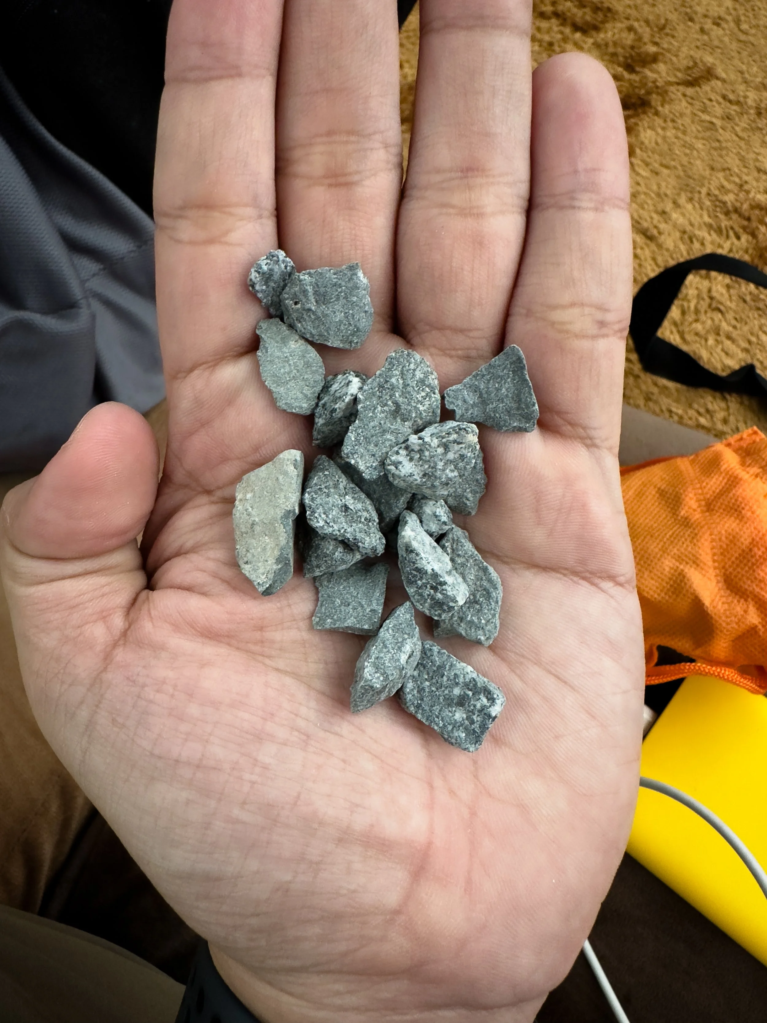 Muzdalifah, Saudi Arabia — Pebbles collected from the plains of Muzdalifah, held in an open palm before the ritual. Small stones. Enormous intention. This is what the ritual looks like before it begins.