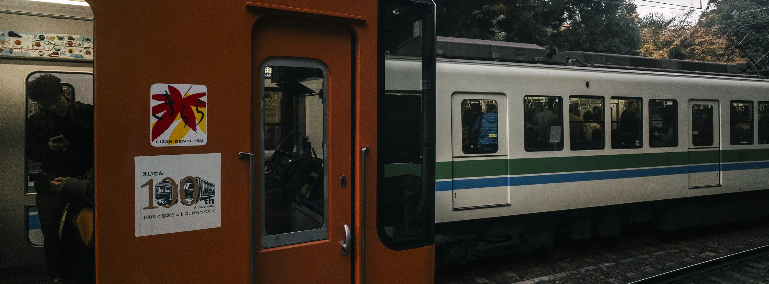 Eizan Dentetsu, Kyoto — A 100th anniversary sticker on the carriage door — a quiet landmark in a country where railways outlast generations. The detail most passengers walk past without noticing.
