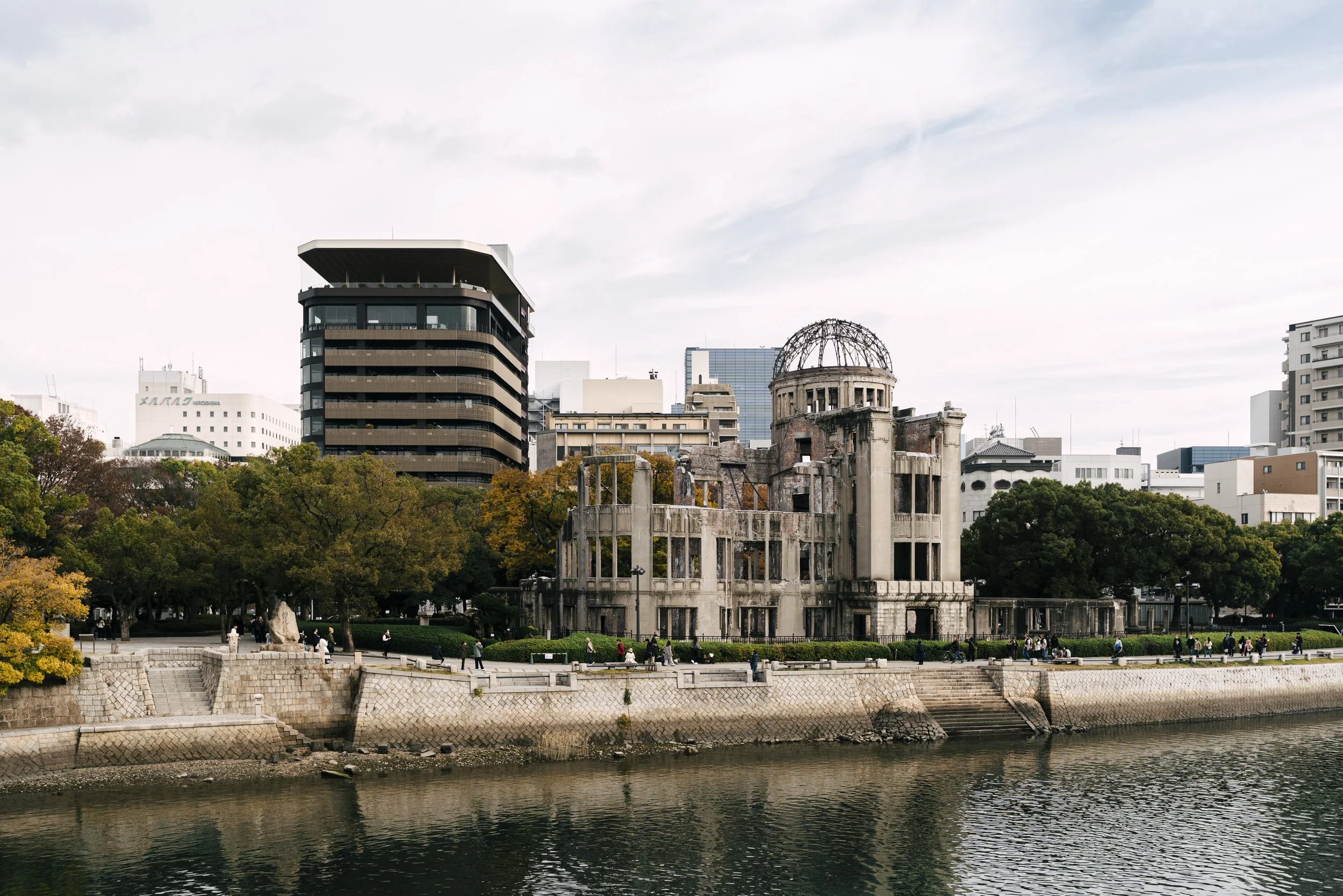  The Genbaku Dome stands across the Motoyasu River, surrounded by autumn trees and the rebuilt cityscape of Hiroshima.