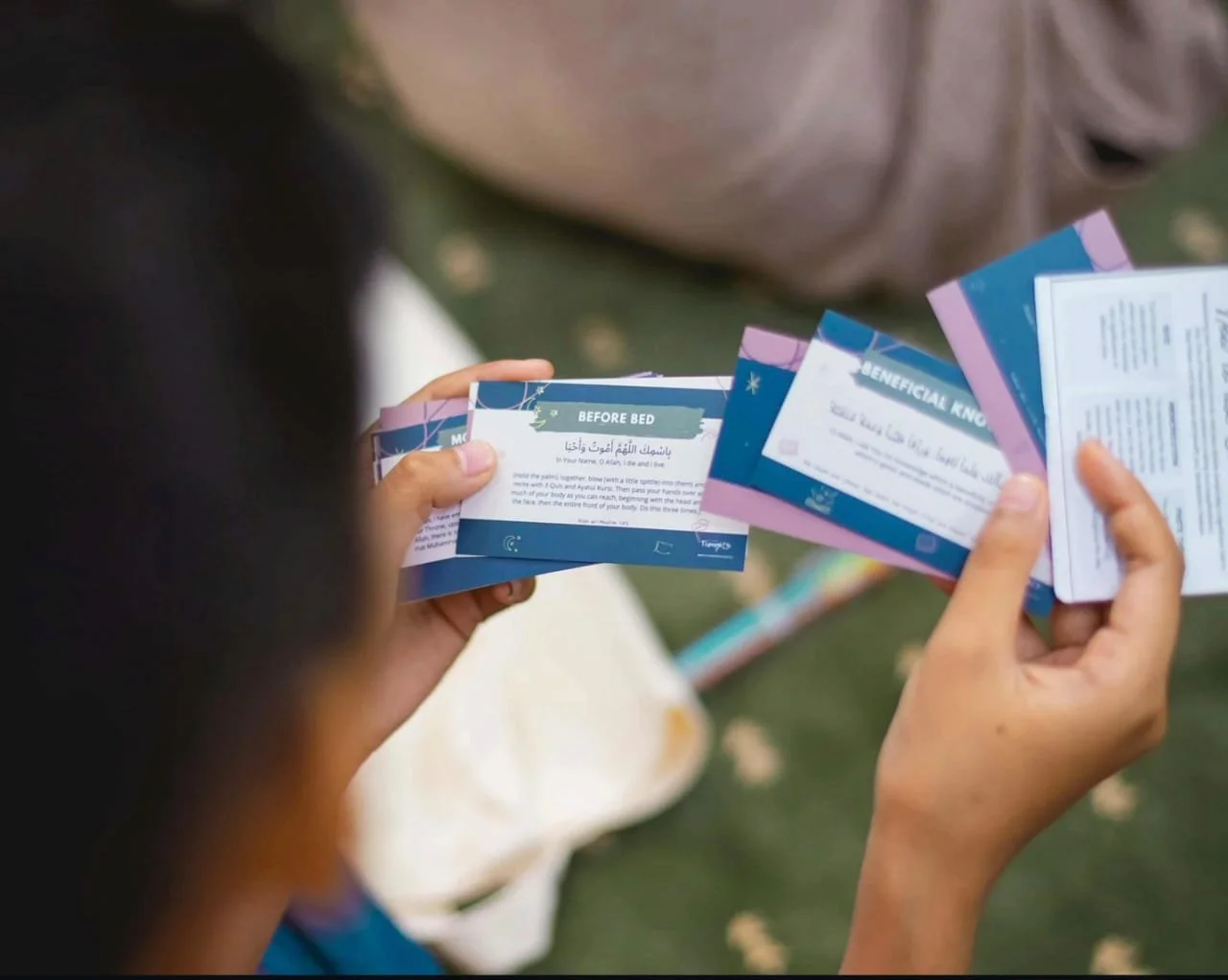 Child flipping through informational pamphlets outdoors, with the pamphlets containing health or safety tips.