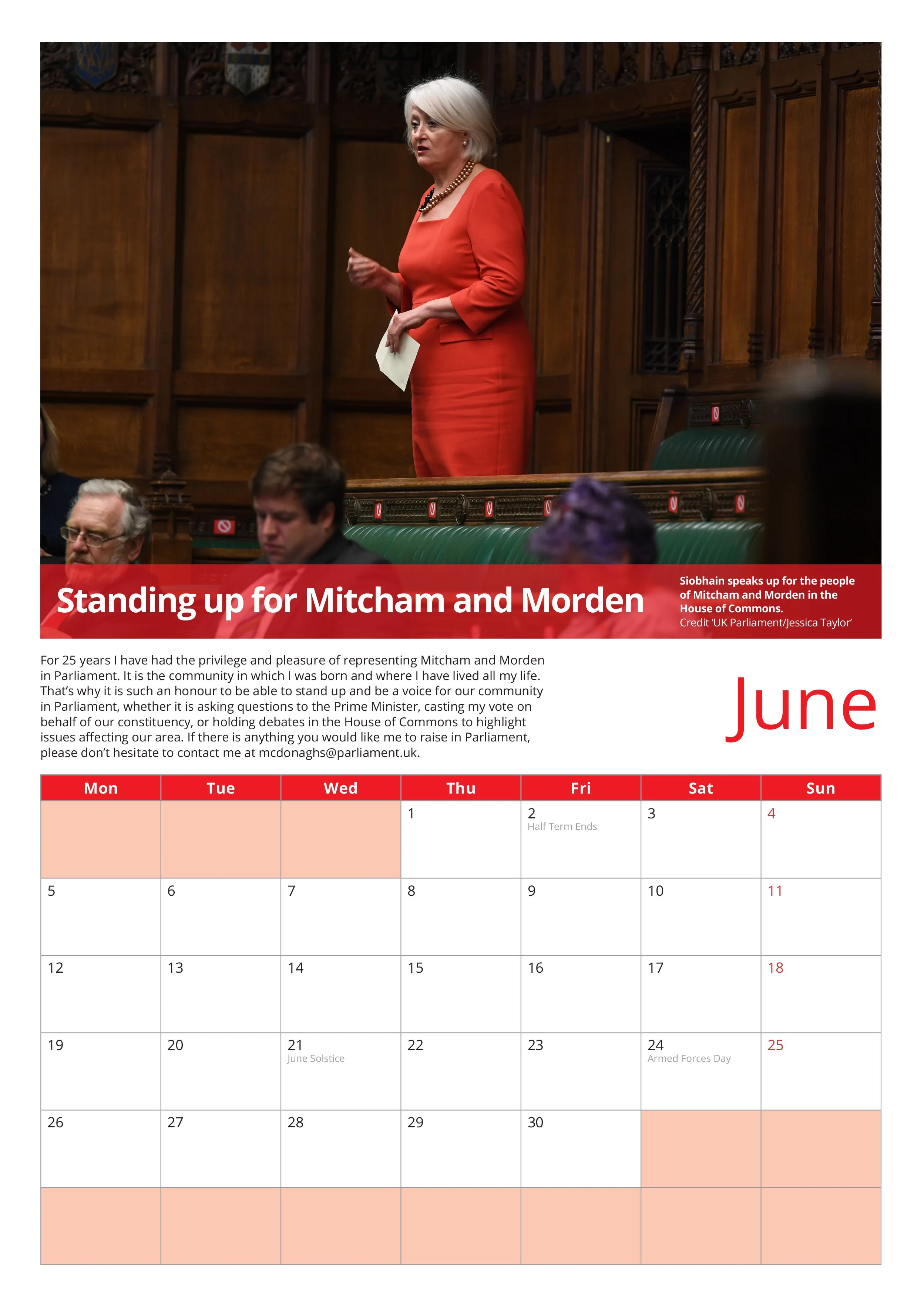 A woman in a red dress speaking in the House of Commons with wooden paneling behind her. There are seated individuals in front of her, and a calendar for June is visible at the bottom.