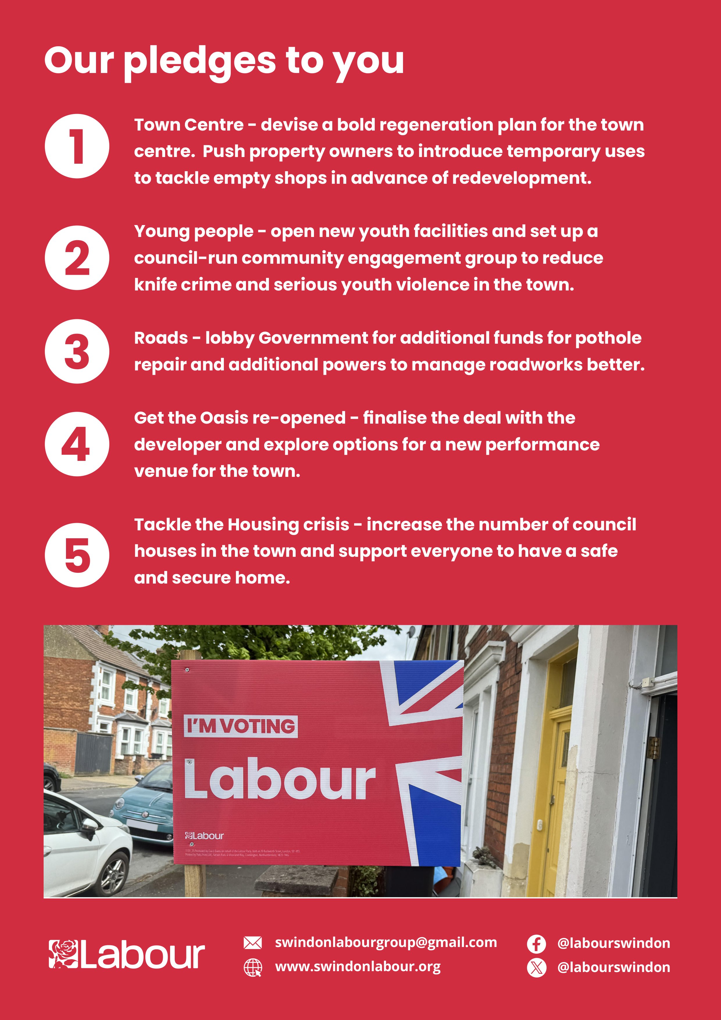A street view with a red Labour party poster in the forefront and a second Labour poster with the words 'I'm voting Labour' and feature a Union Jack. There are parked cars on the street and brick houses on the sidewalk.