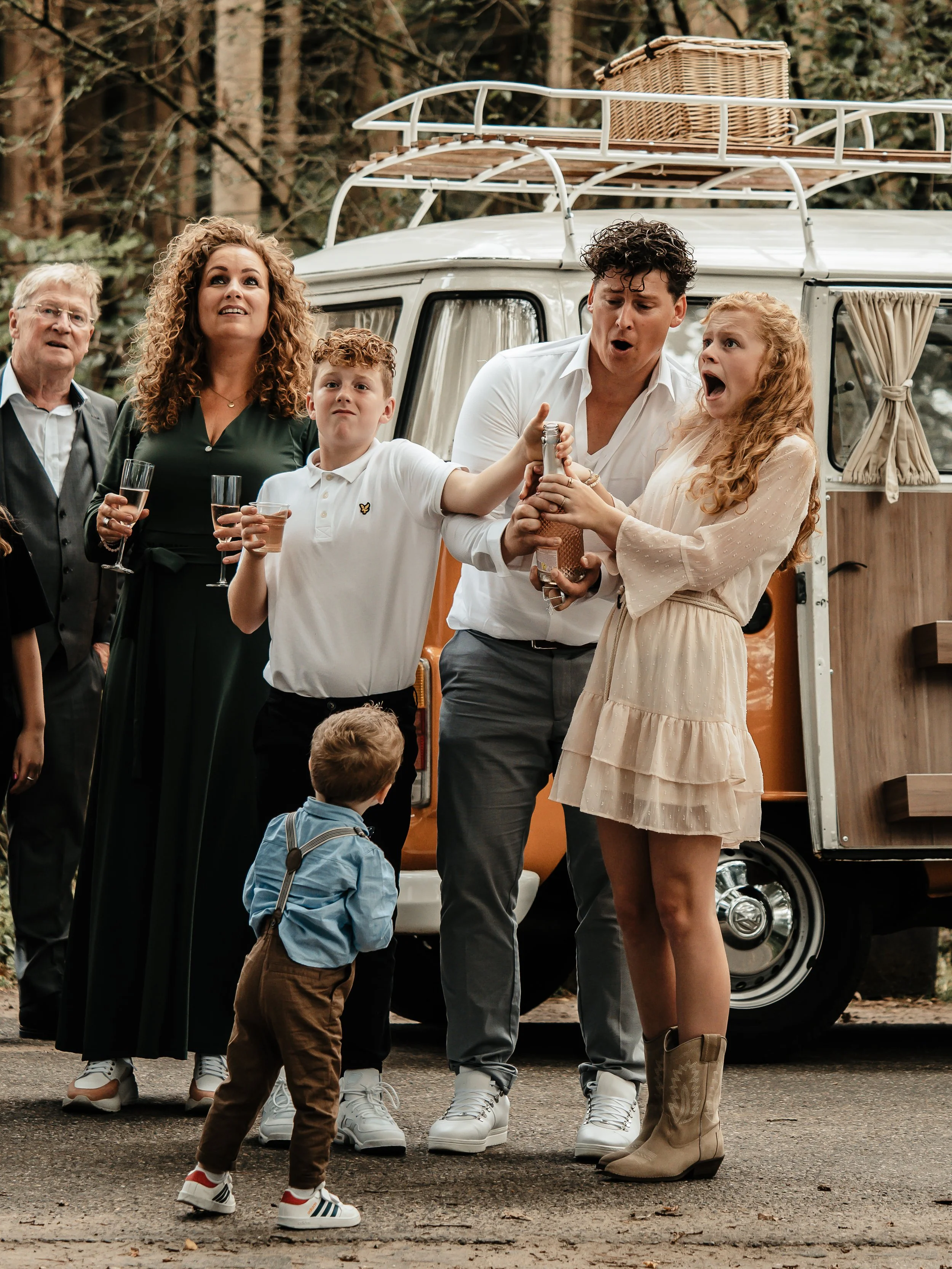 bruidsreportage met vw-busjes waarbij de champagne fles wordt gepropt