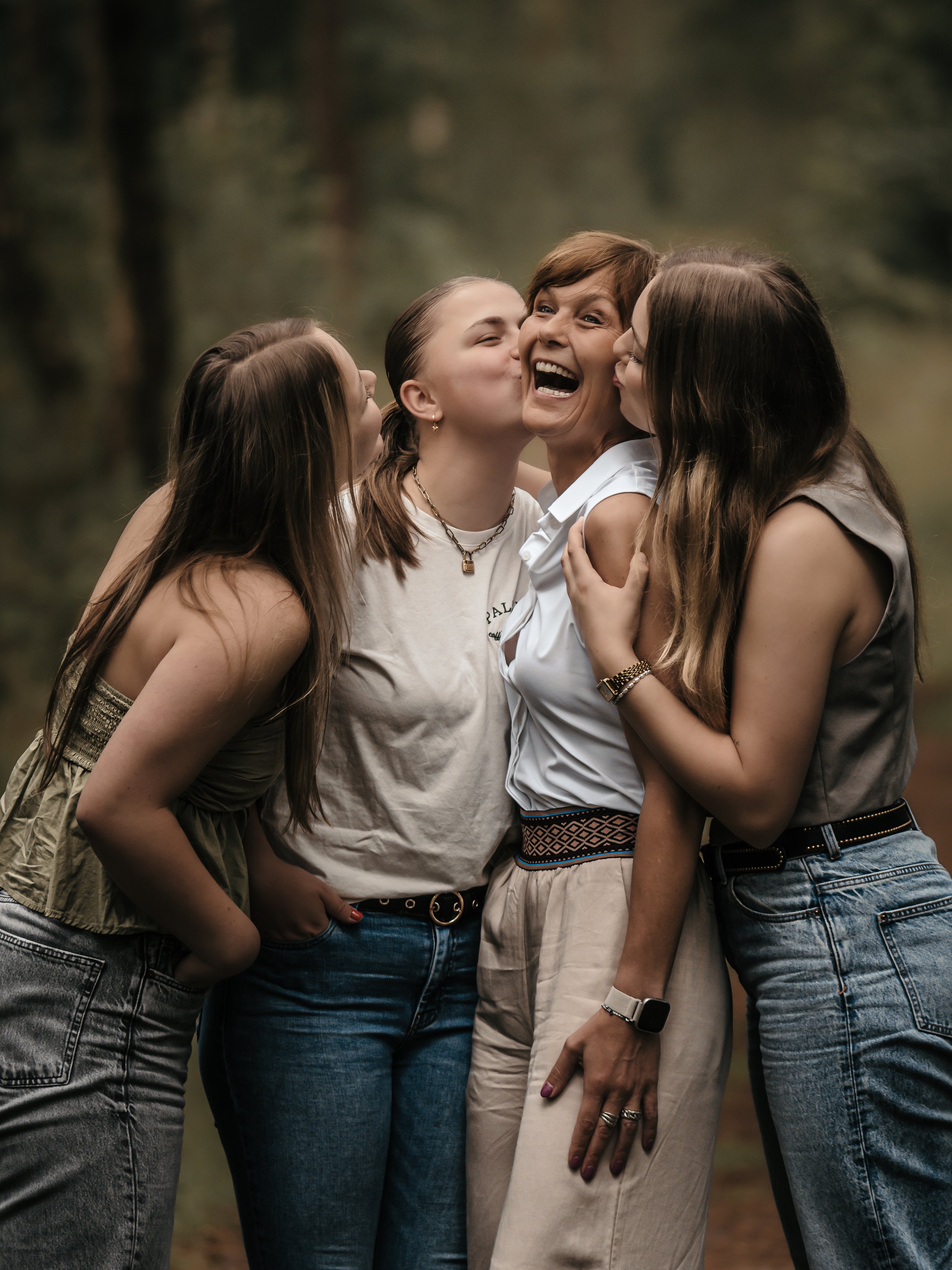 moederdag waarbij mama door haar tienerdochters wordt gezoend