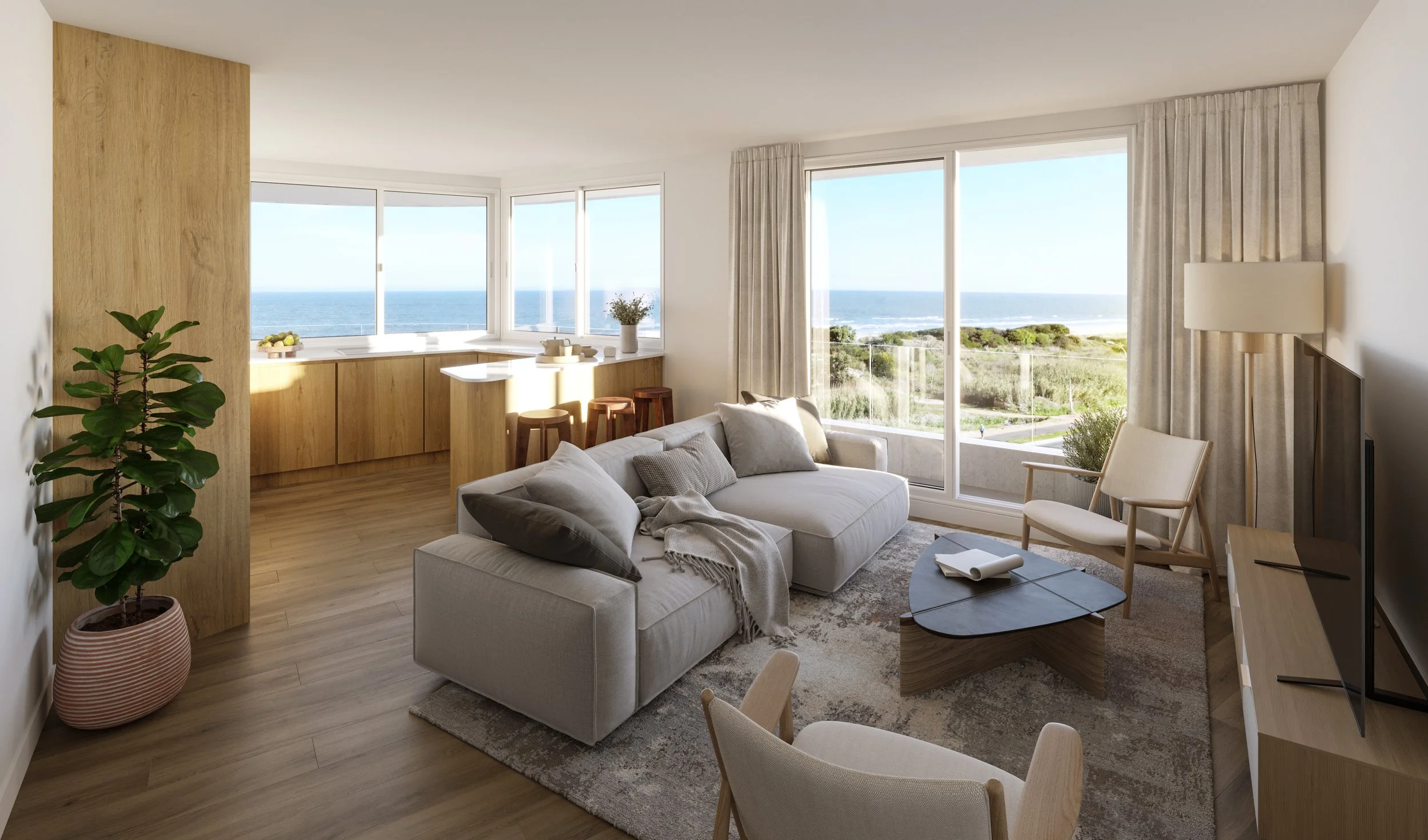 Living room with large windows overlooking the ocean, white sofa with throw pillows, wooden coffee table, potted plant, and a view of the sea and greenery outside.