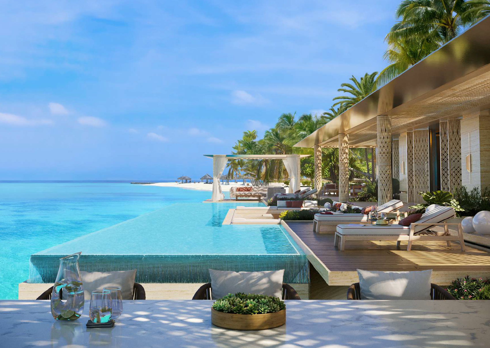 Luxury beachfront resort with infinity pool, shaded lounge area, palm trees, and ocean view under blue sky.