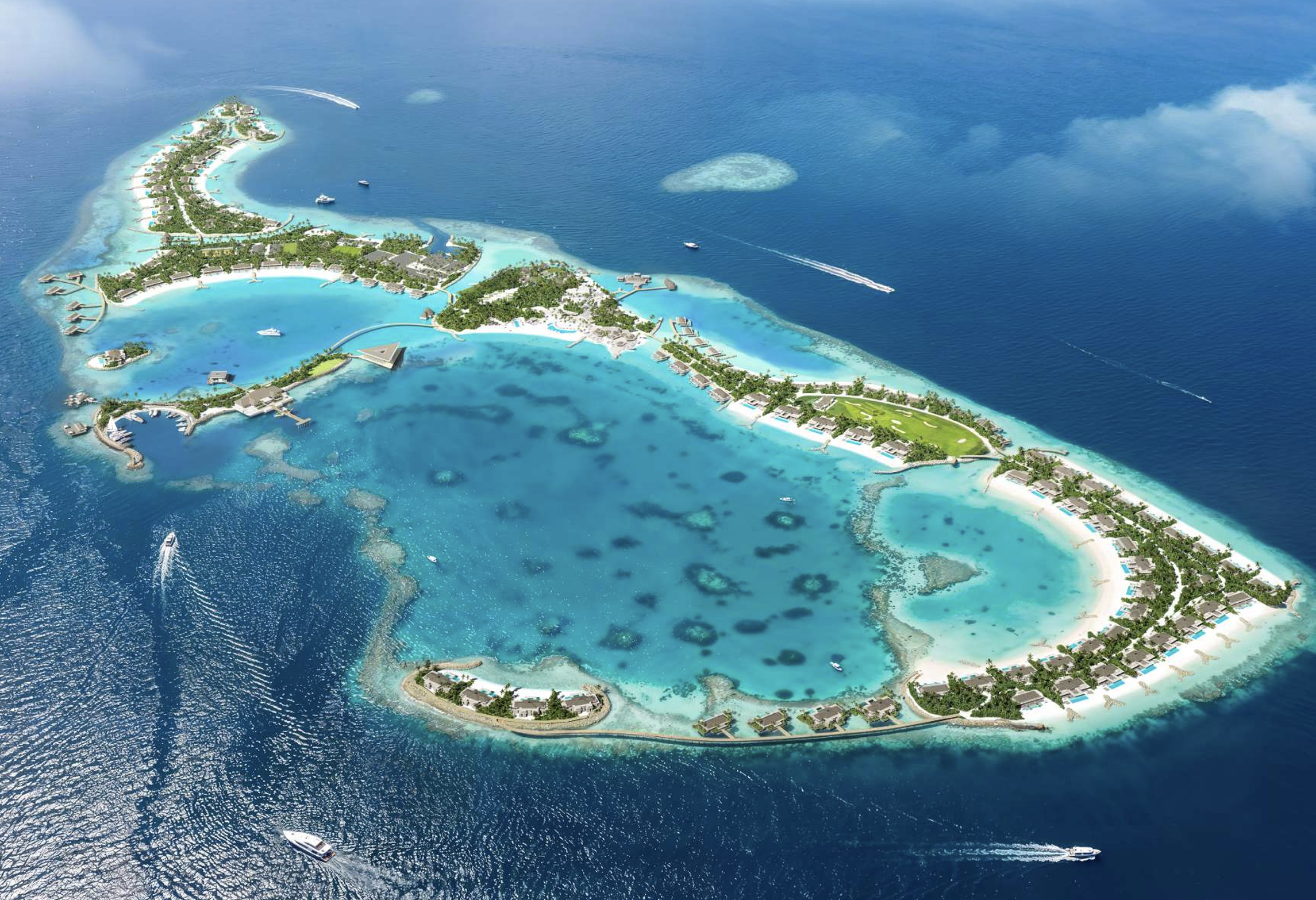 Aerial view of a tropical island resort with overwater bungalows, lush greenery, and surrounding turquoise ocean with boats and watercraft.