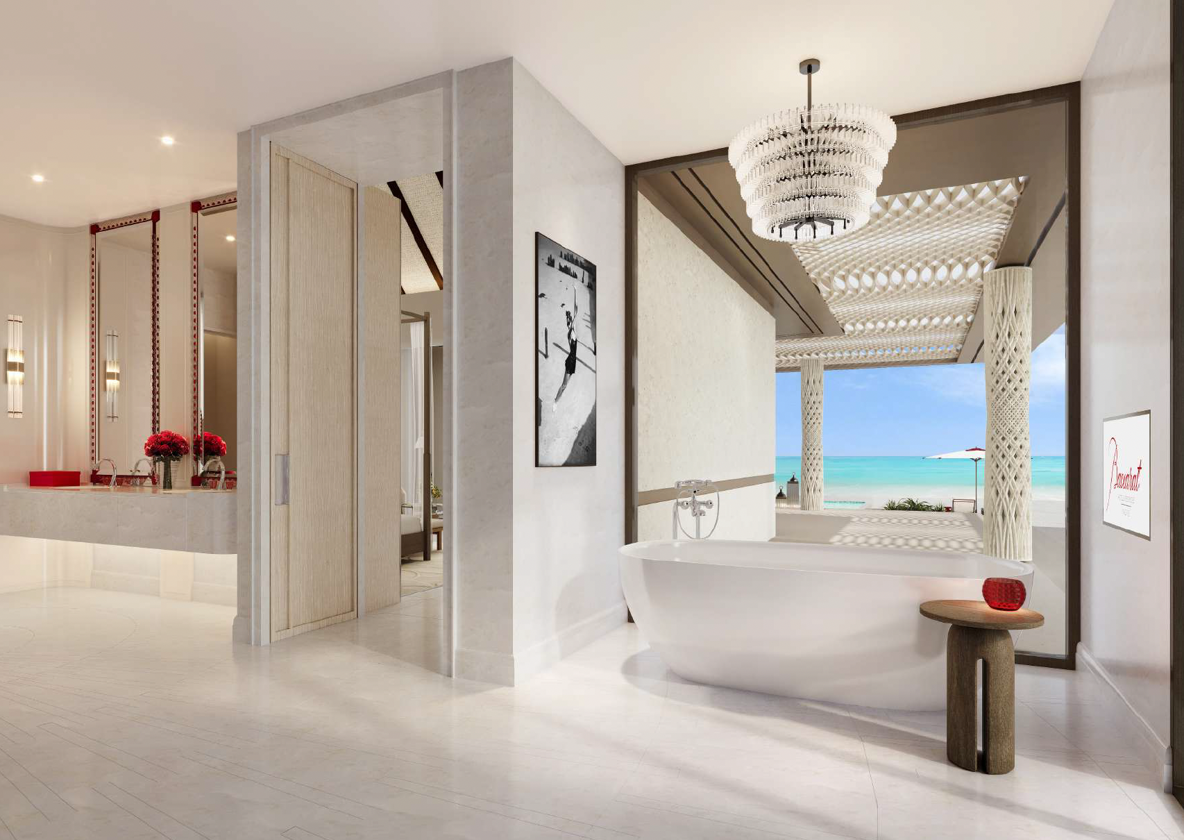 Luxurious indoor bathroom with a view of a beach, featuring a white bathtub, a small wooden side table with a red decorative object, a chandelier, and an open space leading to an outdoor patio with columns and a view of the ocean.