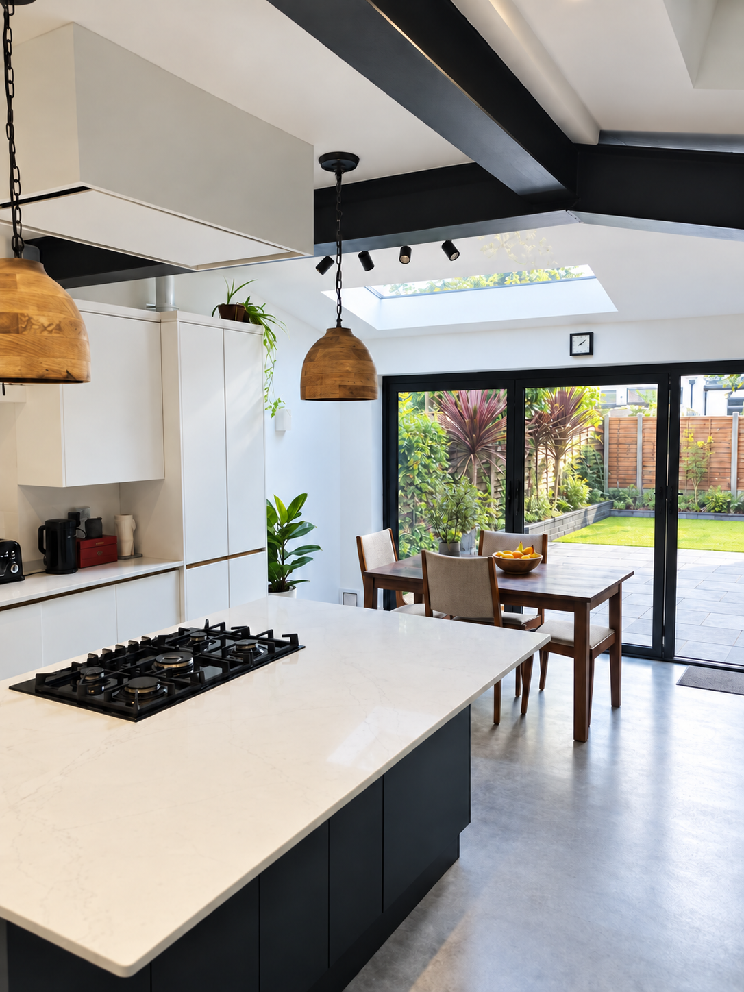 Modern kitchen and dining extension in Epsom featuring bifold doors opening onto a newly landscaped patio, creating a seamless indoor-outdoor living space.