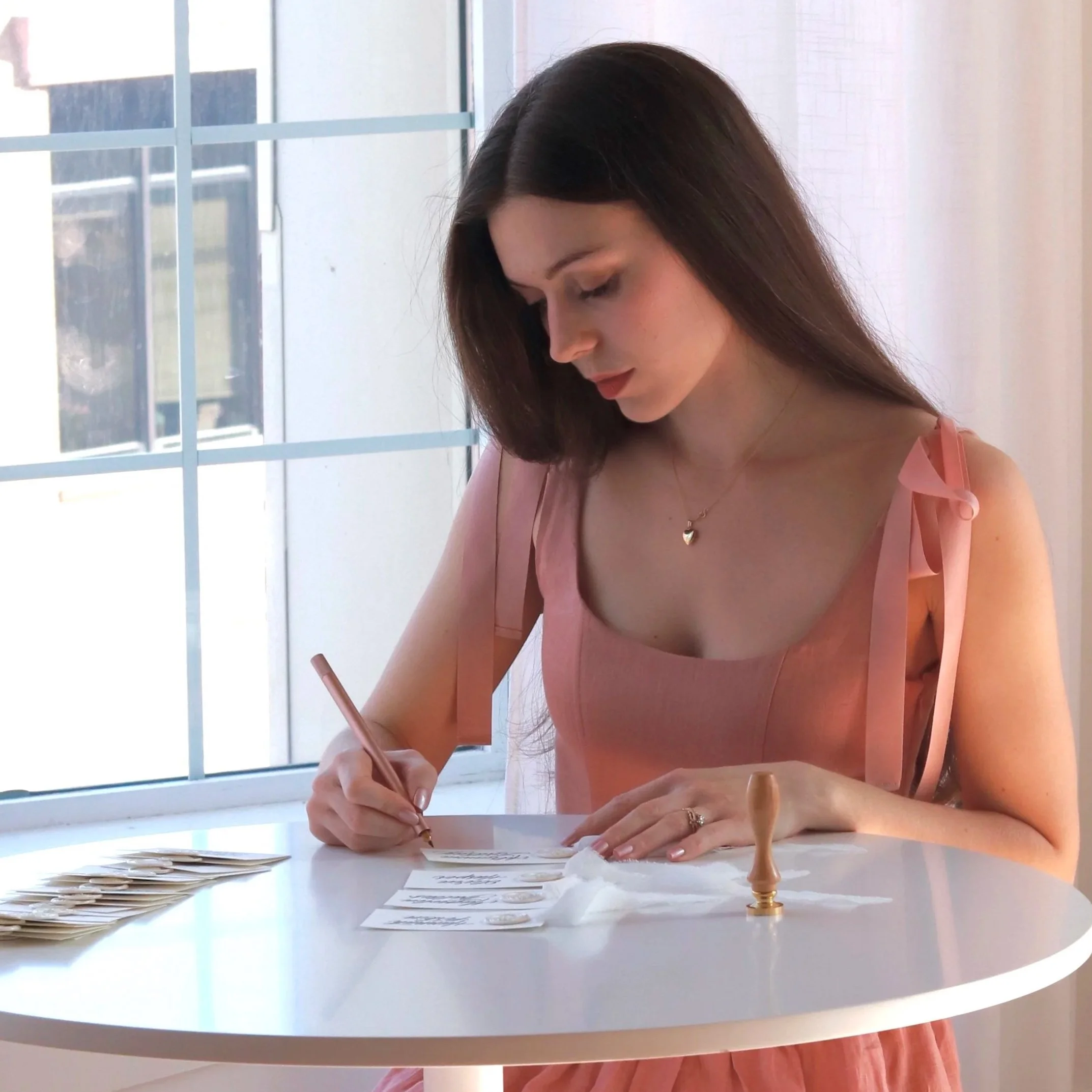 Belle Anderson creating handwritten calligraphy place cards during a live event setup