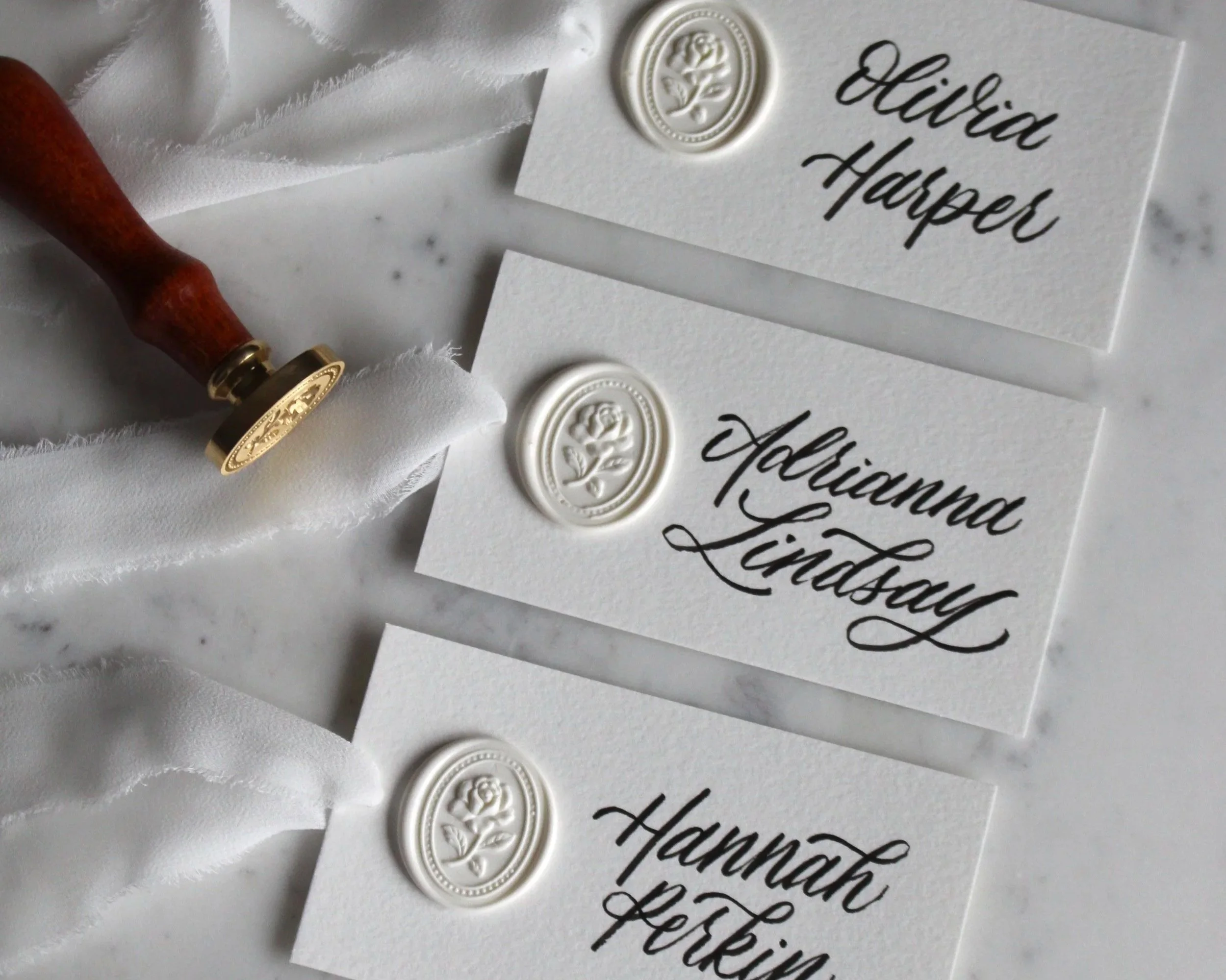 Elegant calligraphy workshop place cards with handwritten names and wax seals