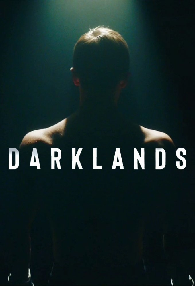 A dark, shadowy image of a person with short hair, lit from above, with the word 'DARKLANDS' written across the front.