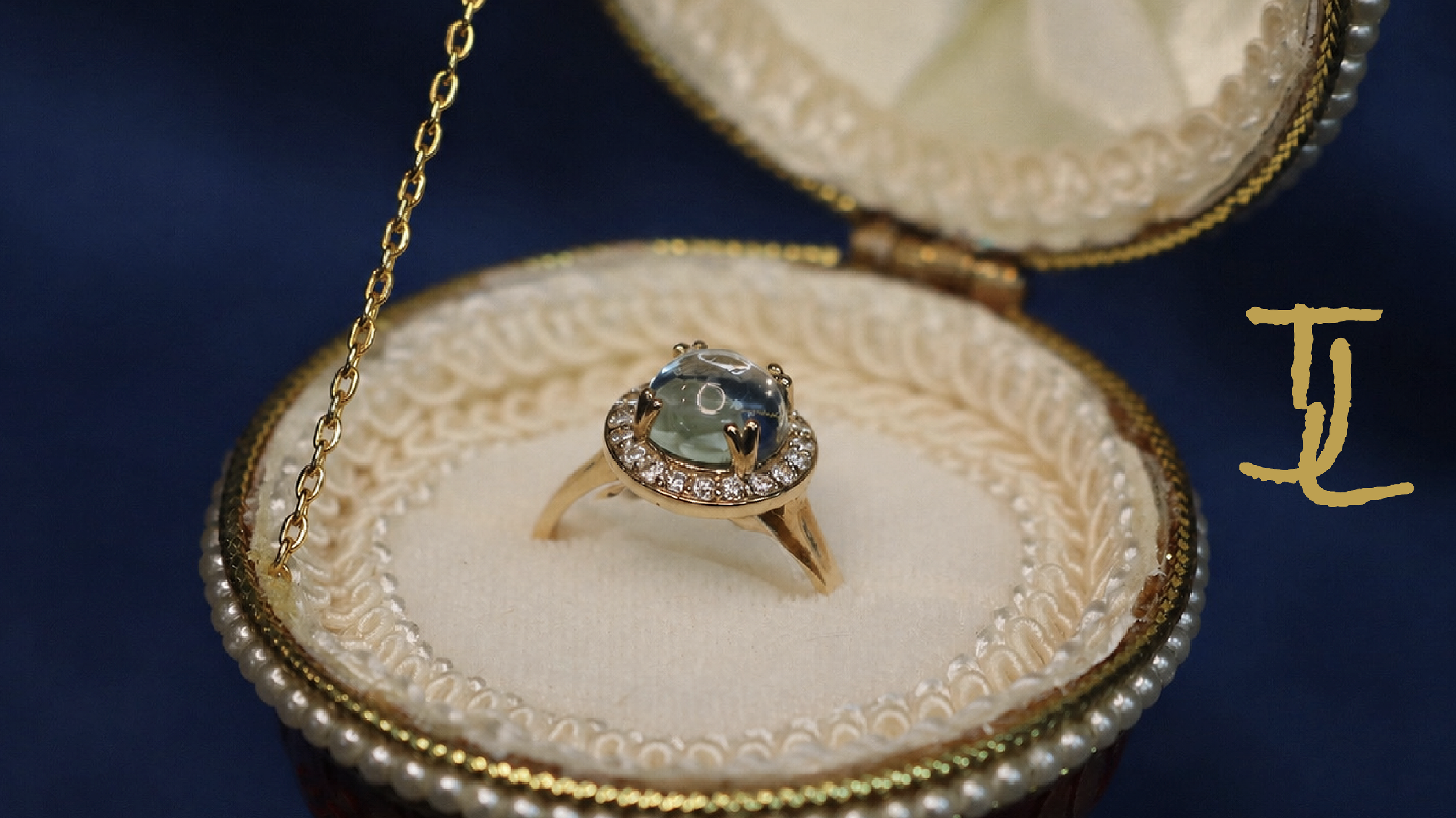 A gold ring with a large, transparent gemstone surrounded by smaller diamonds, placed inside an ornate jewelry box with lace and pearl details.