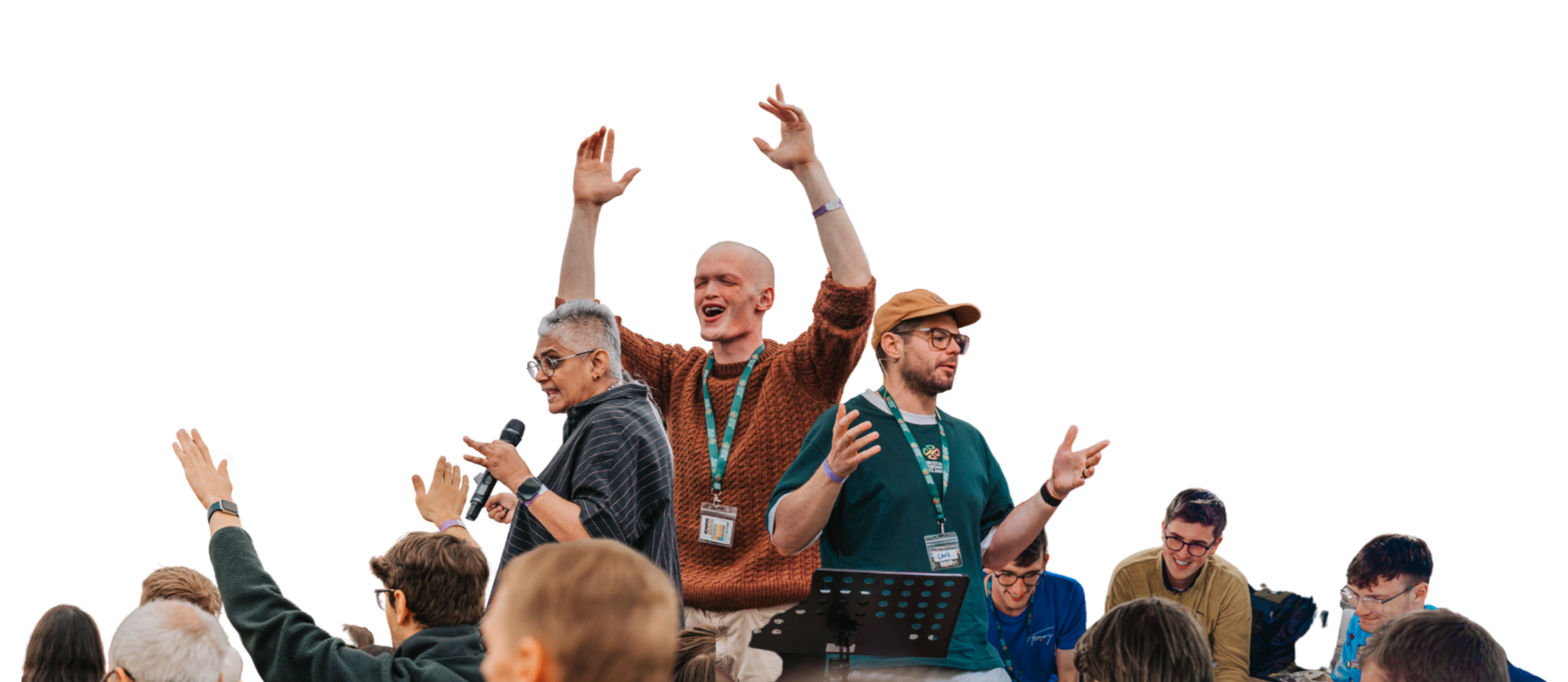 Group of diverse adults at a conference or event, some speaking, some smiling, and engaging with each other, in an indoor setting.