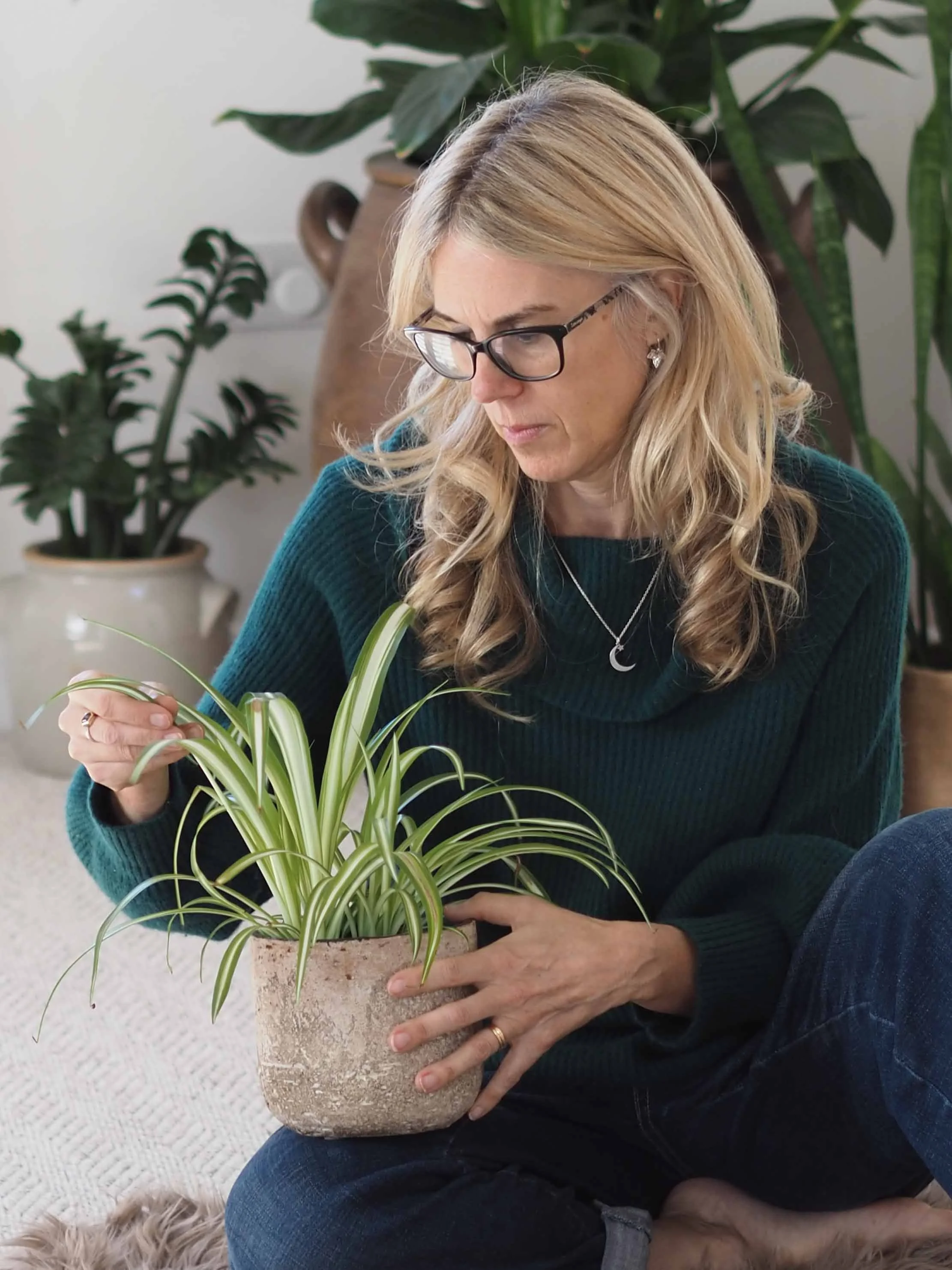 Photo of Claire Branigan soul based coach white blond middle aged woman holding a plant
