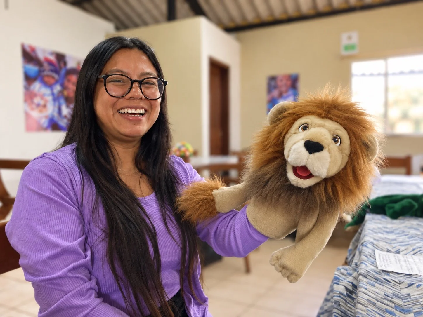 Mili Rivas, a children's minister from Guatemala, smiling and holding a lion puppet