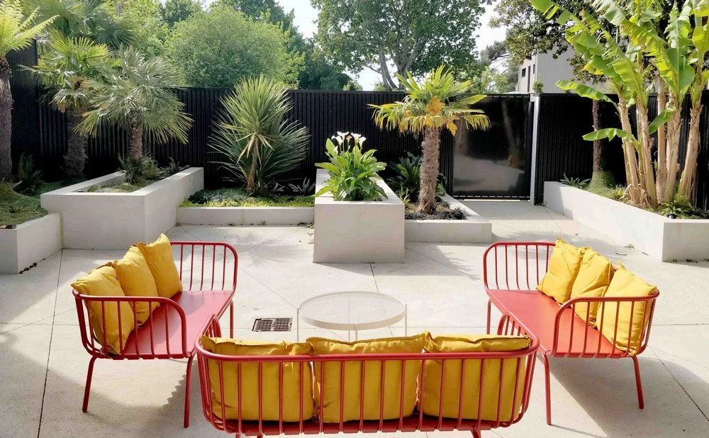 Terrasse extérieure aménagée pour location de salle à Nantes avec mobilier design coloré et jardin exotique chez Rokyo à Trentemoult