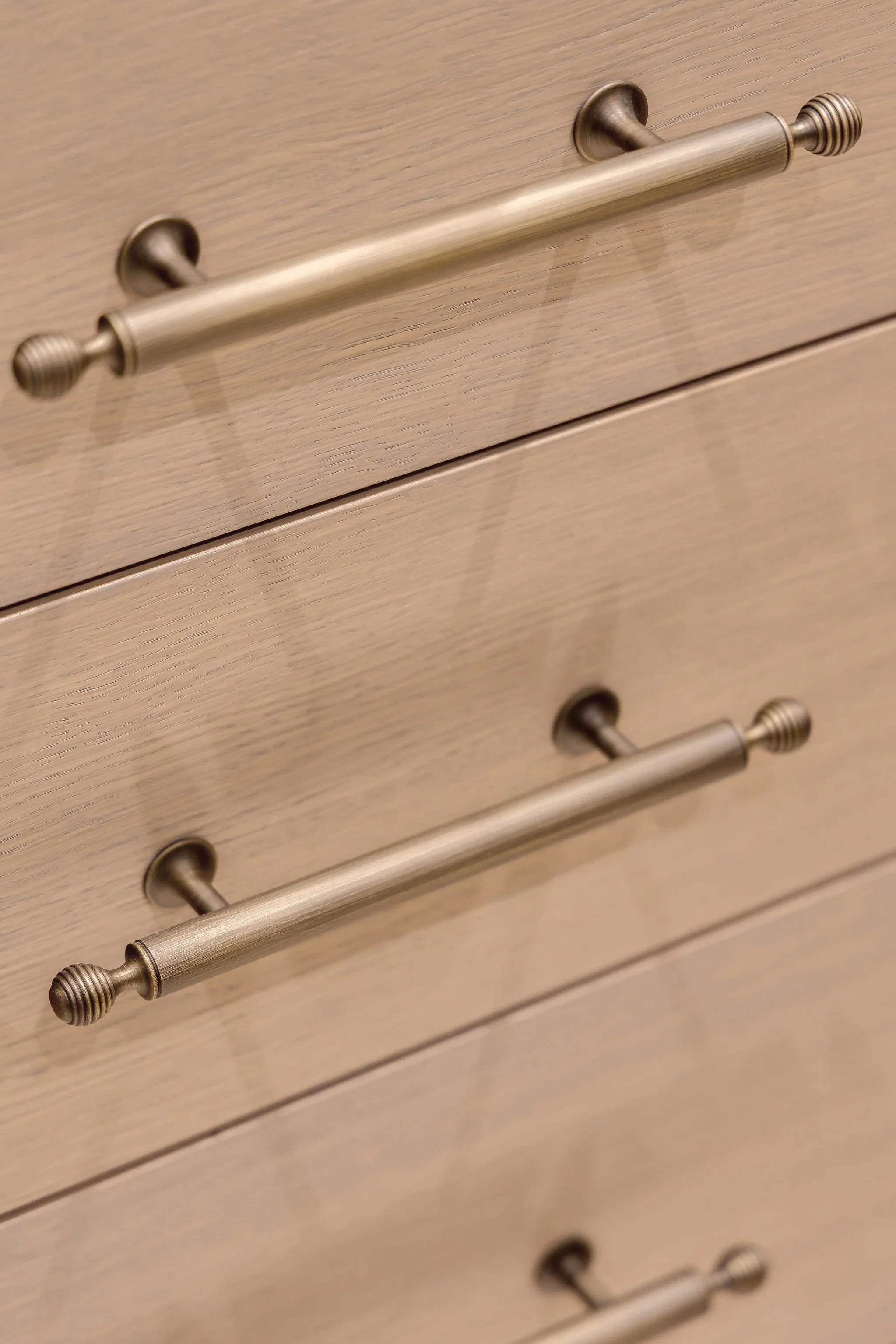 Close-up of a wooden dresser drawer with a metallic handle.