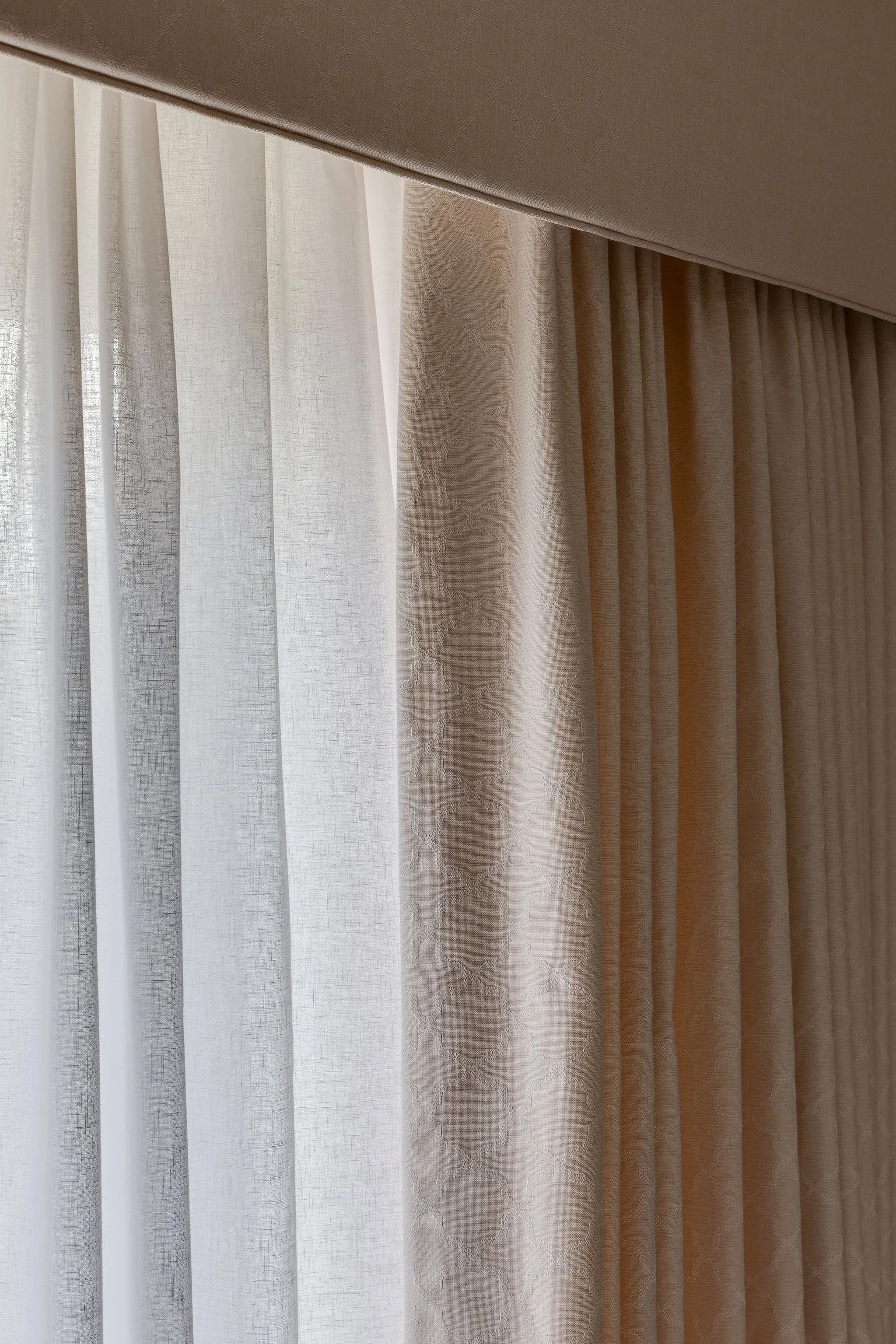 A close-up photo of beige curtains with light filtering through, creating a soft and airy ambiance.