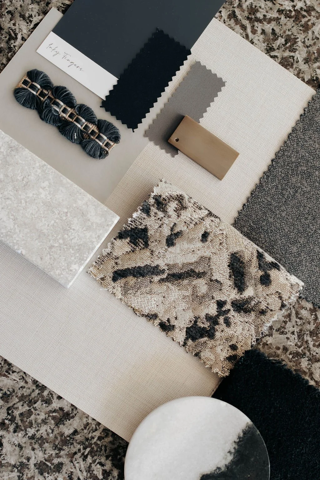 A collection of interior design and fabric samples including color swatches, textured tiles, a decorative fabric piece, and a small wooden sample, arranged on a surface.