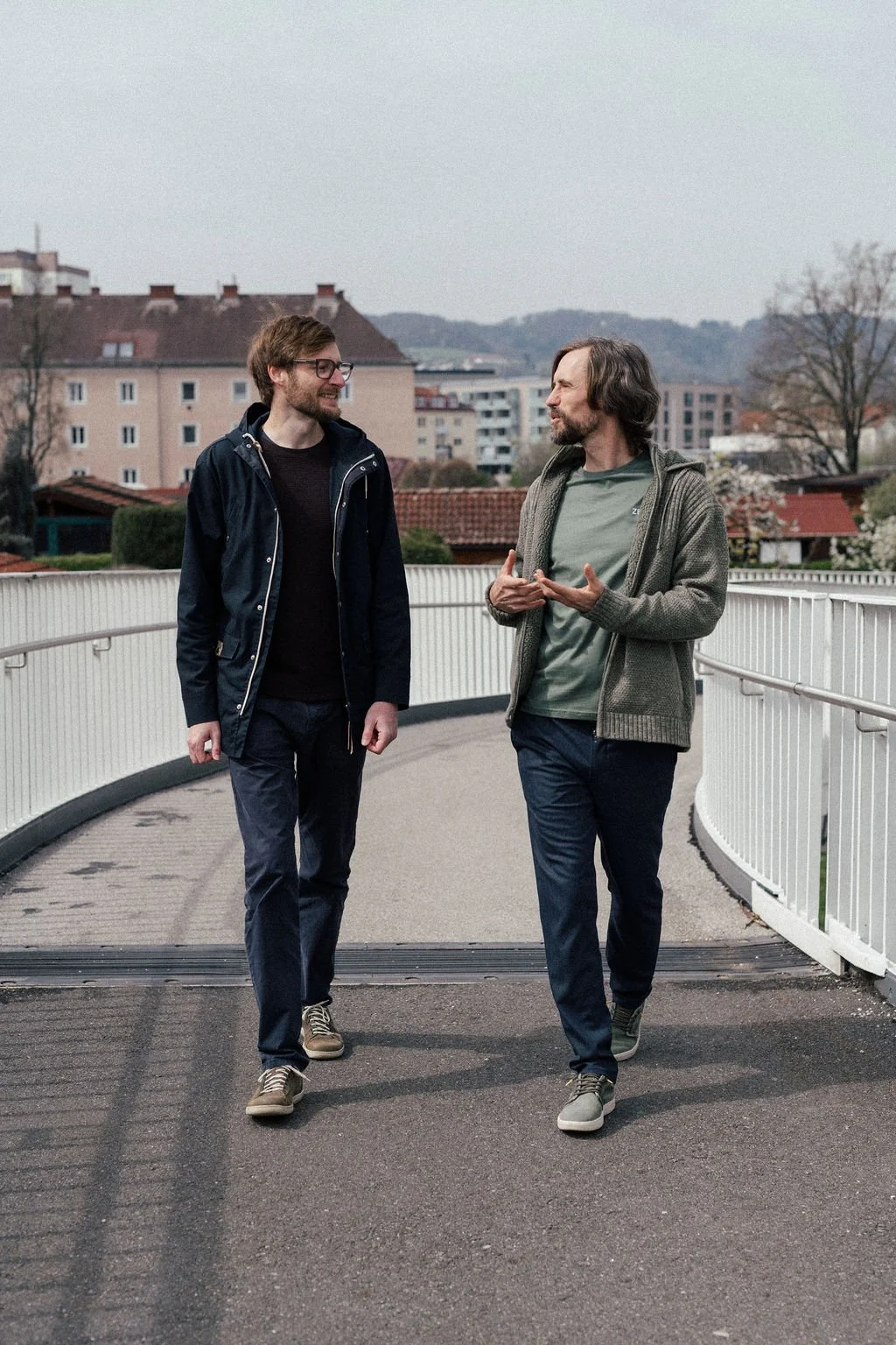 Andreas Fuka im Gespräch mit einem Klienten auf einer Fußgängerbrücke