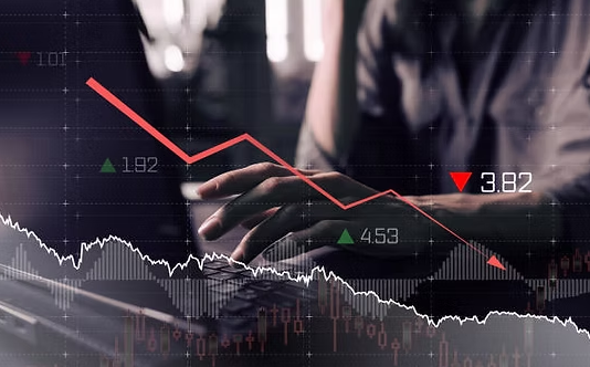 A person using a tablet with financial graphs and stock market data displayed on a digital screen.