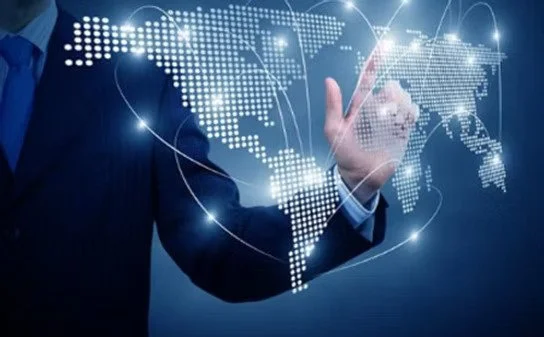 A person in a suit touching a digital world map hologram with glowing lines connecting different continents.