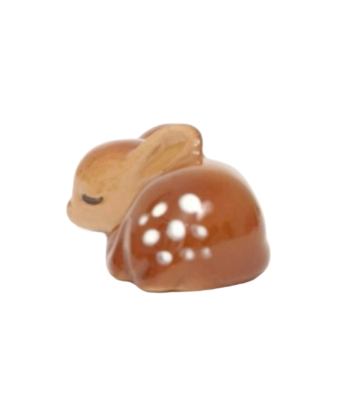 A small chocolate and vanilla pastry with white icing dots and a tiny bunny-shaped cookie on top.