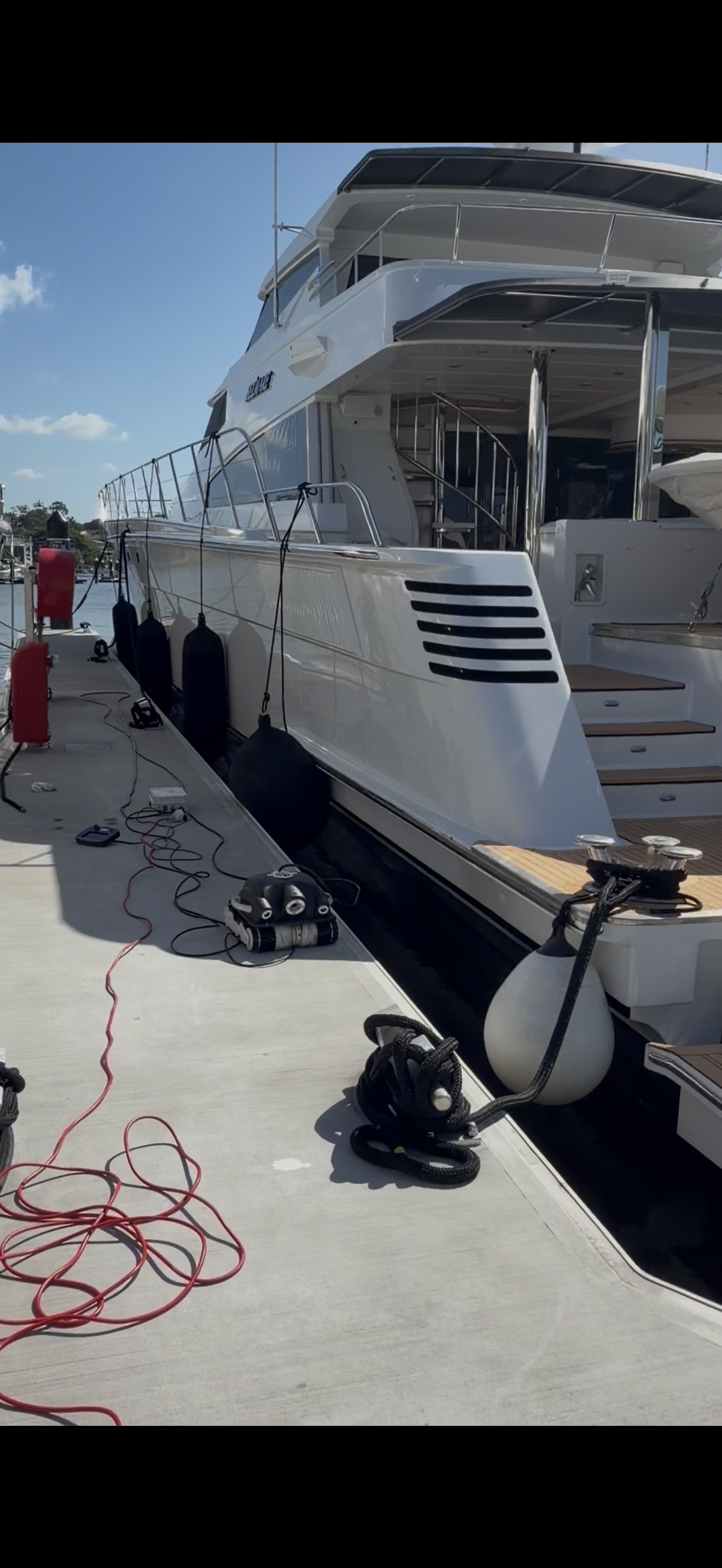 A large white yacht docked at a marina