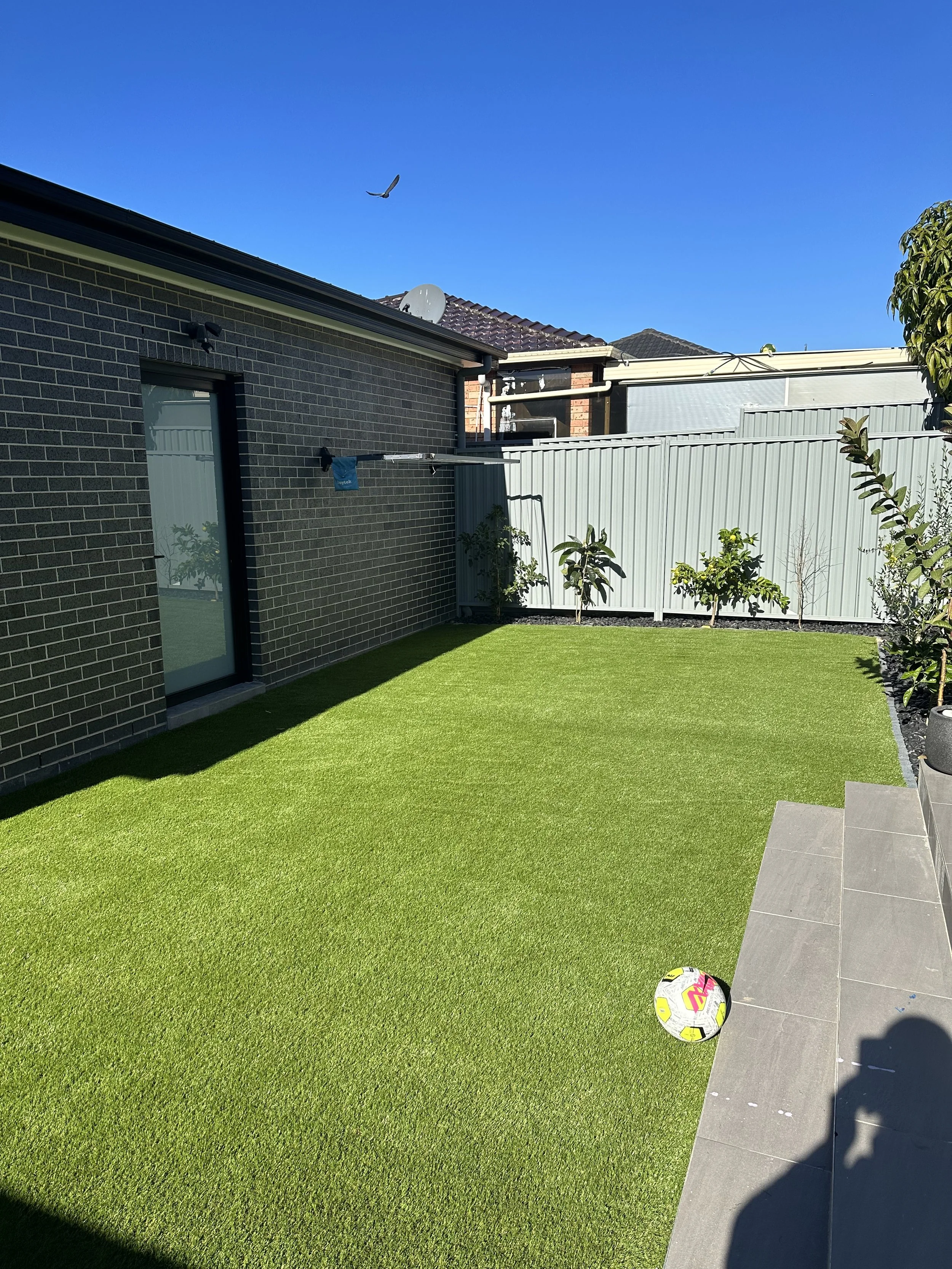 A backyard with synthetic grass installed by Greenscape Turfing Sydney