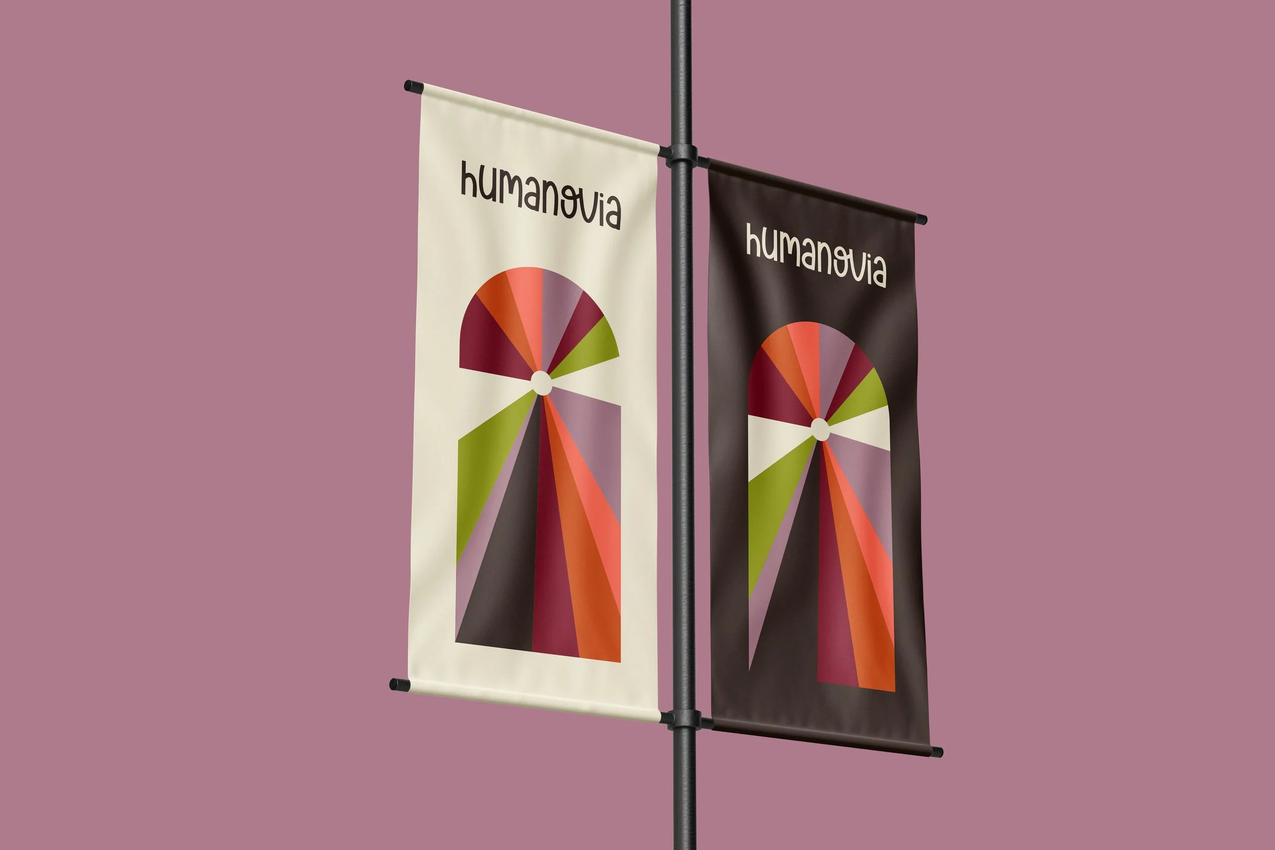Deux drapeaux suspendus sur un mât, un blanc et un noir, avec le logo 'humanoVIA' et un graphique en forme de demi-cercle coloré, sur un fond violet