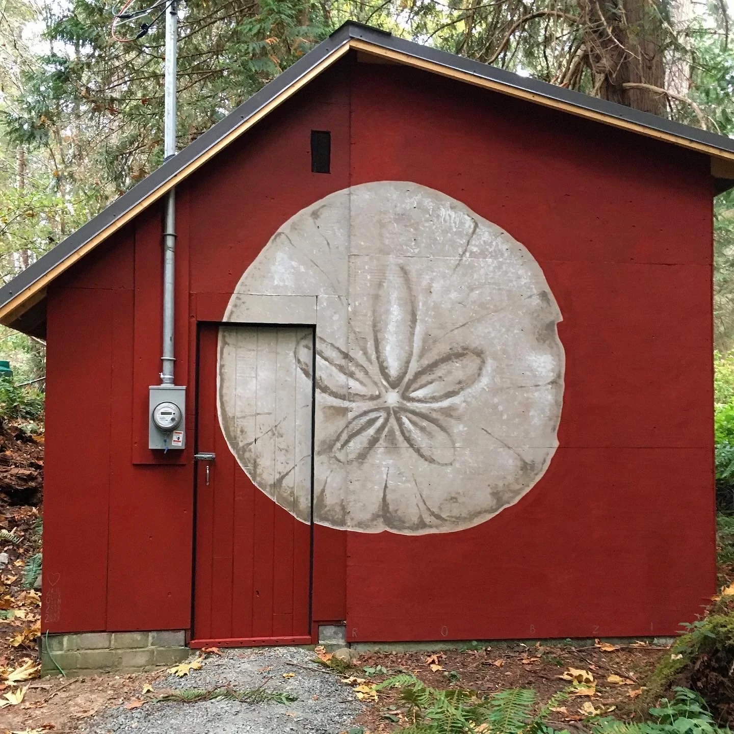 Une petite cabane rouge avec un dessin de tranche de citron peint sur la façade.