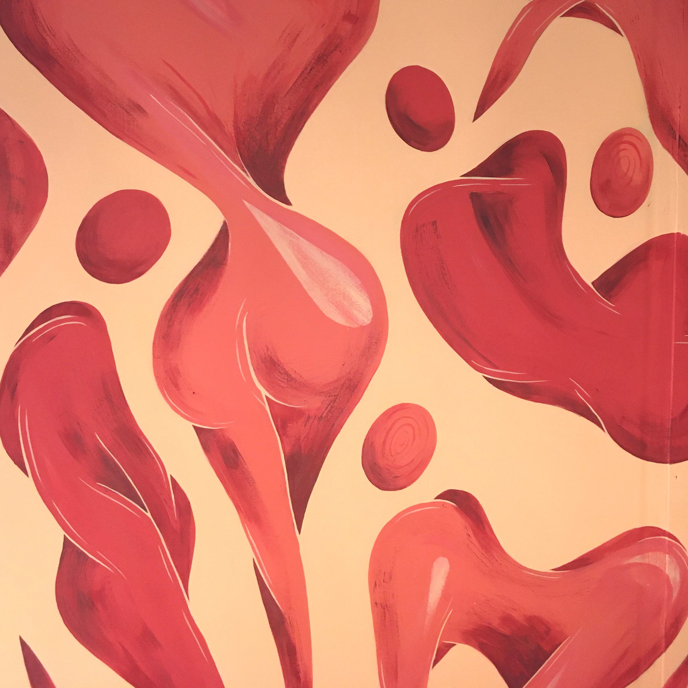 Une peinture abstraite avec des formes de cœurs et de cercles en différentes nuances de rouge et de rose.