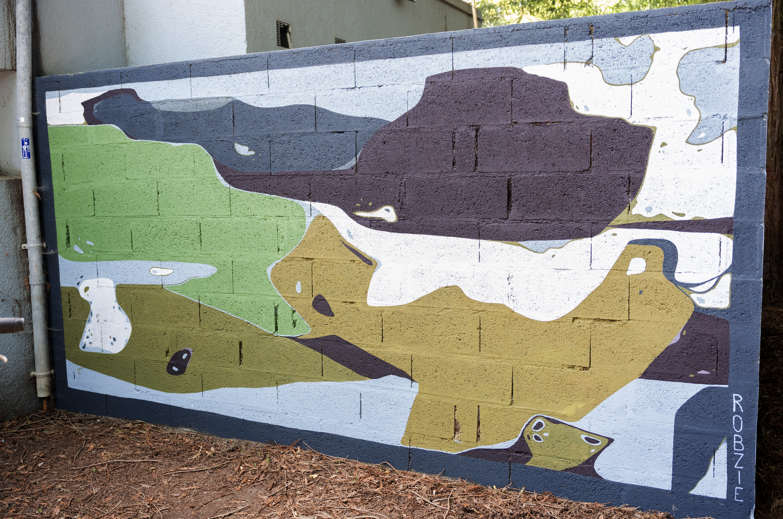 Une fresque murale représentant un canard nageant dans un environnement aquatique avec des eaux bleues, vertes et beige, peinte sur un mur en briques.
