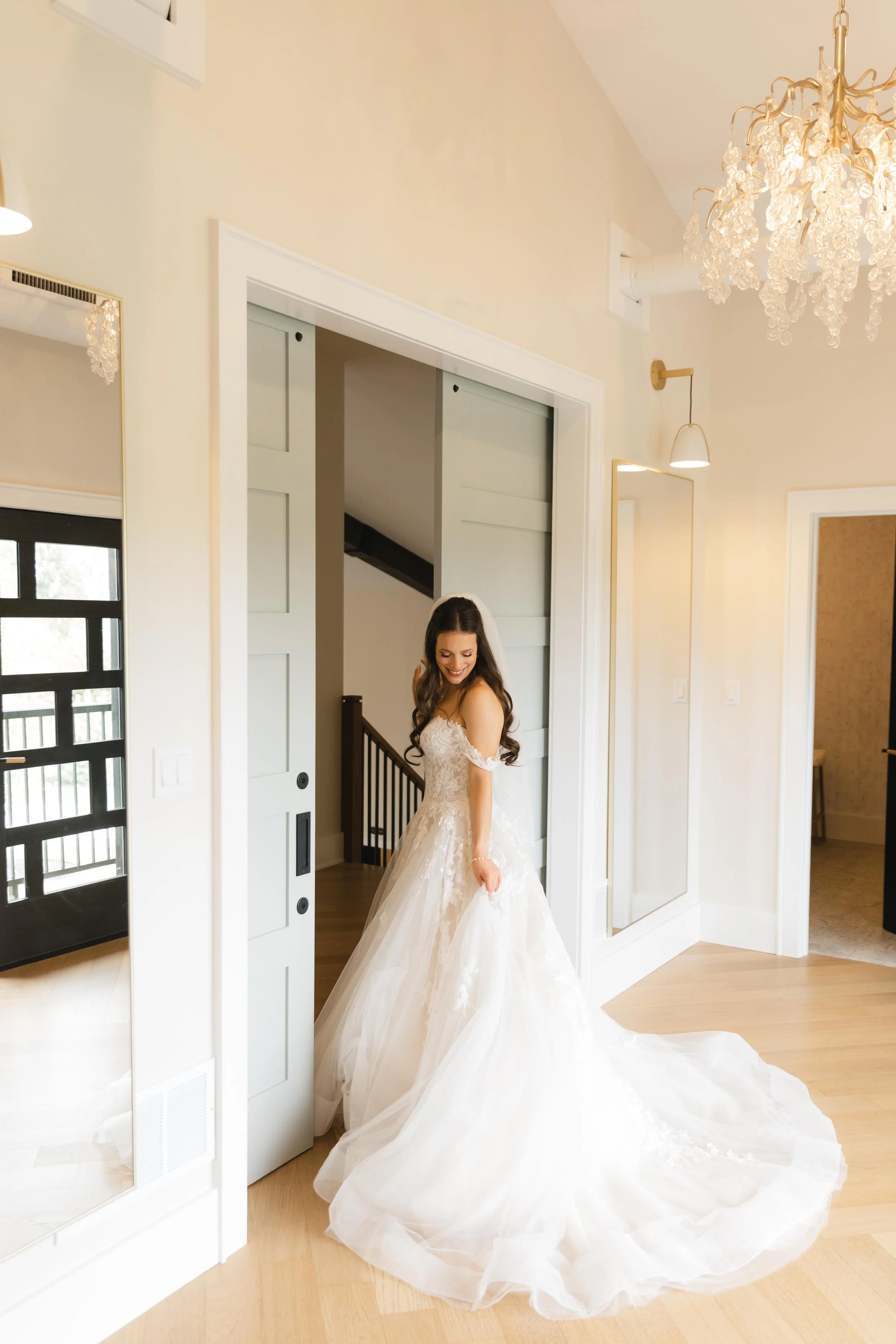bride looking down at her dress in the bridal suite doorway
