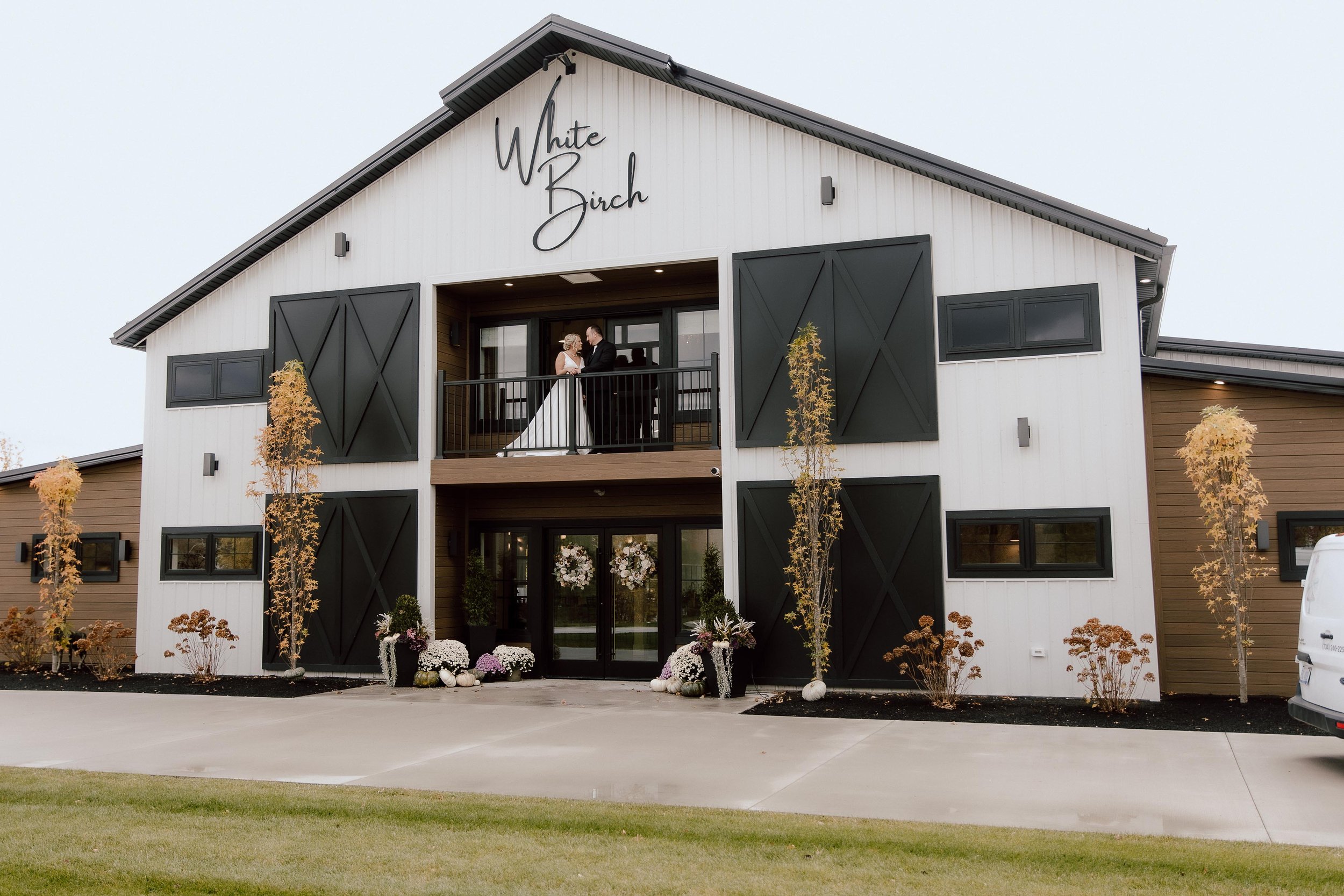 zoomed out shot of the front of the barn, with a couple standing on the balcony
