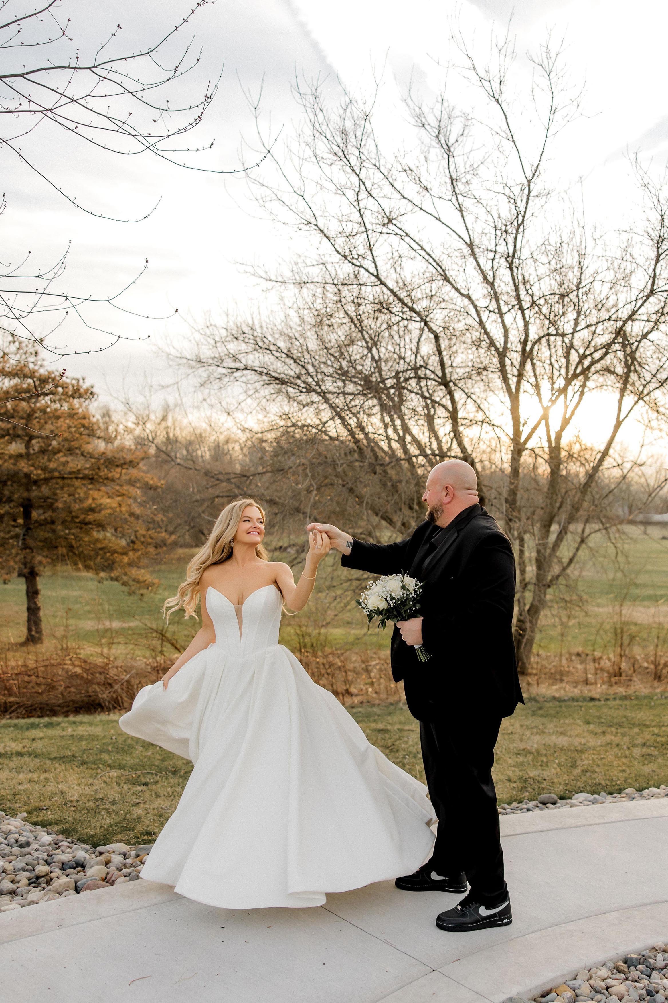 groom and bride twirling in the property, with autumn landscape in the background