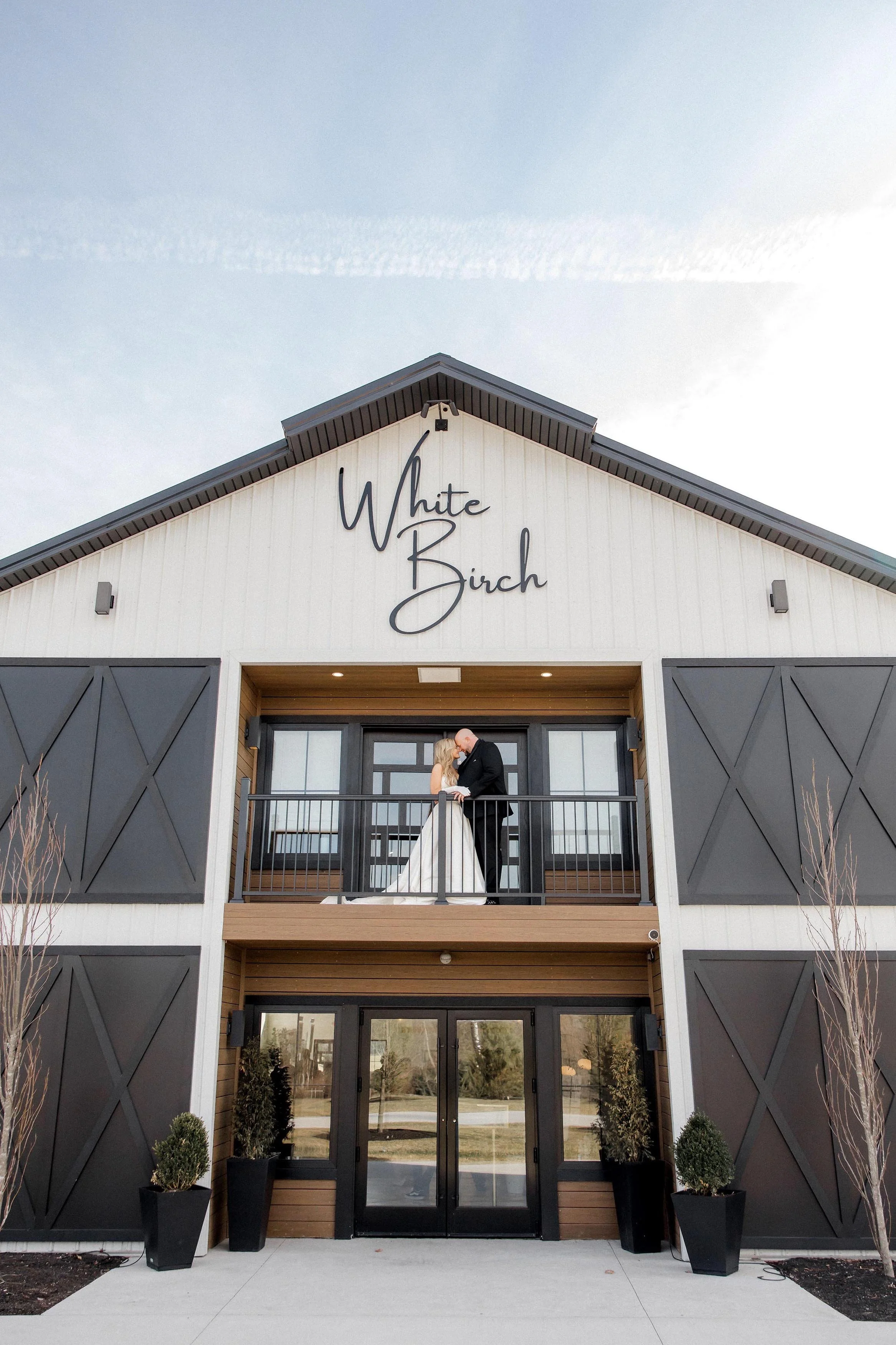 couple kissing on the barn's balcony
