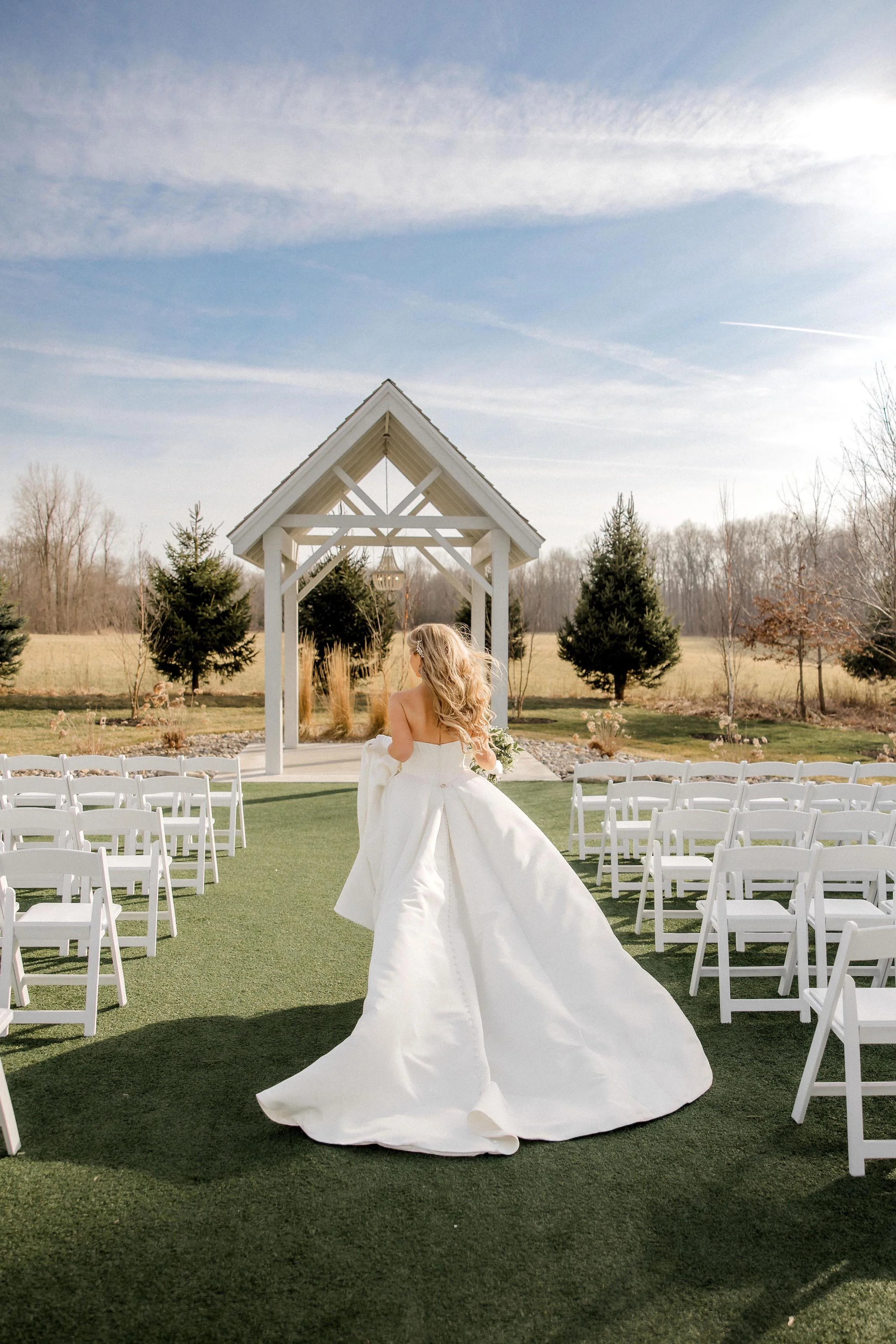 bride looking at her ceremony space with the open-air chapel and autumn landscape in the background