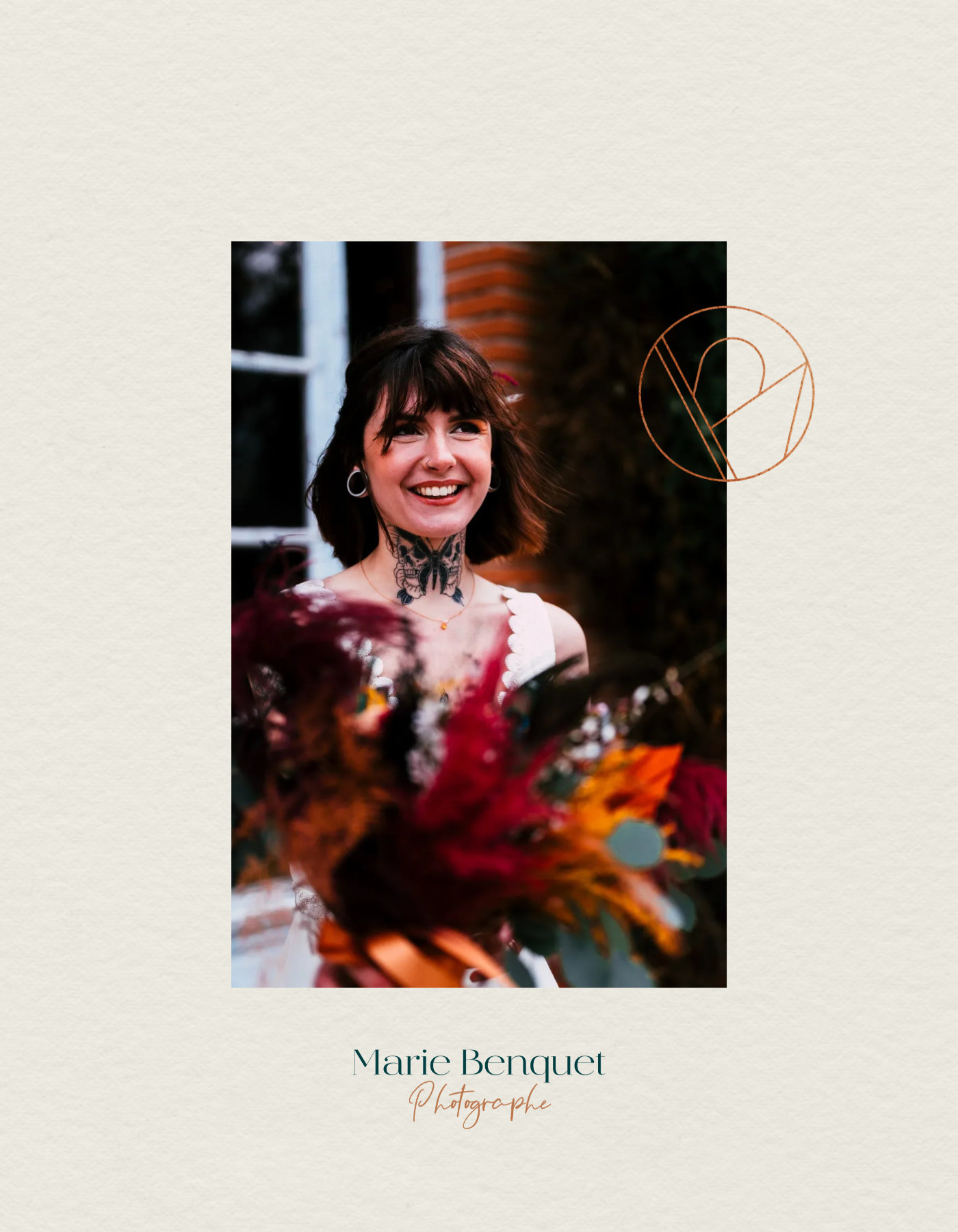 Portrait d'une femme souriante avec tatouage au cou, portant des boucles d'oreilles, devant un mur en brique, entourée de fleurs colorées.