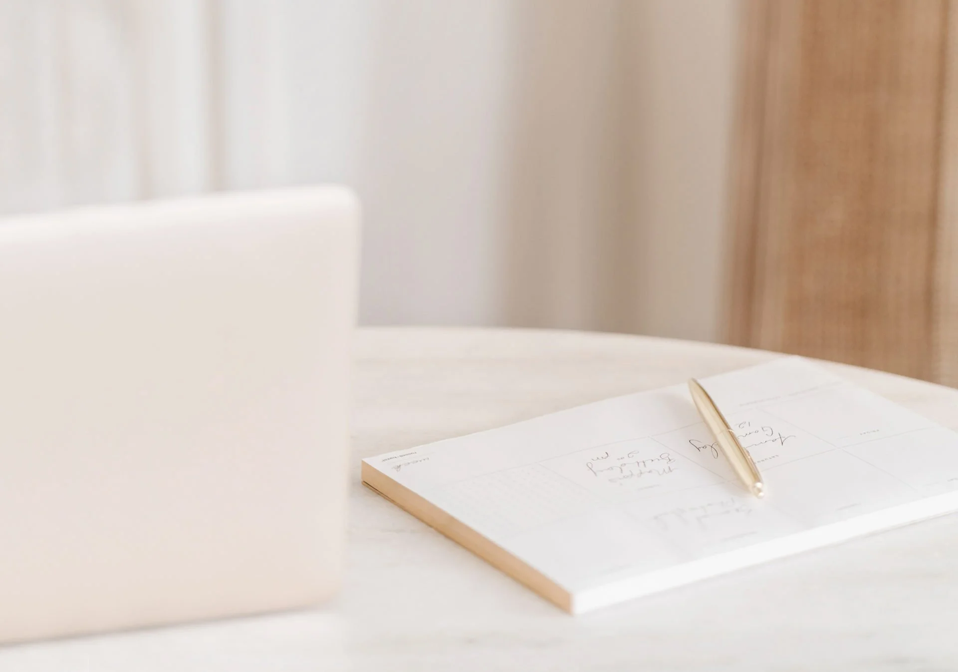 Un carnet posé sur une table avec un stylo posé dessus, dans un environnement clair et neutre.