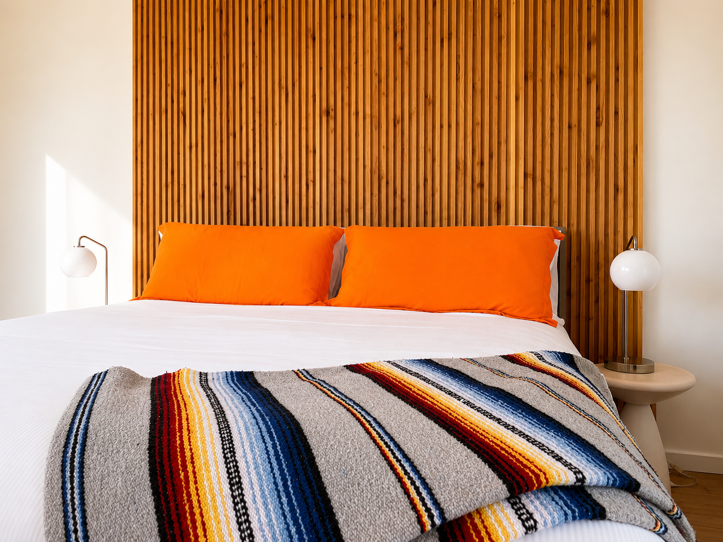 Boutique hotel room with Mexican blanket, wood headboard and Malibu Pier art at The Malibu Motel